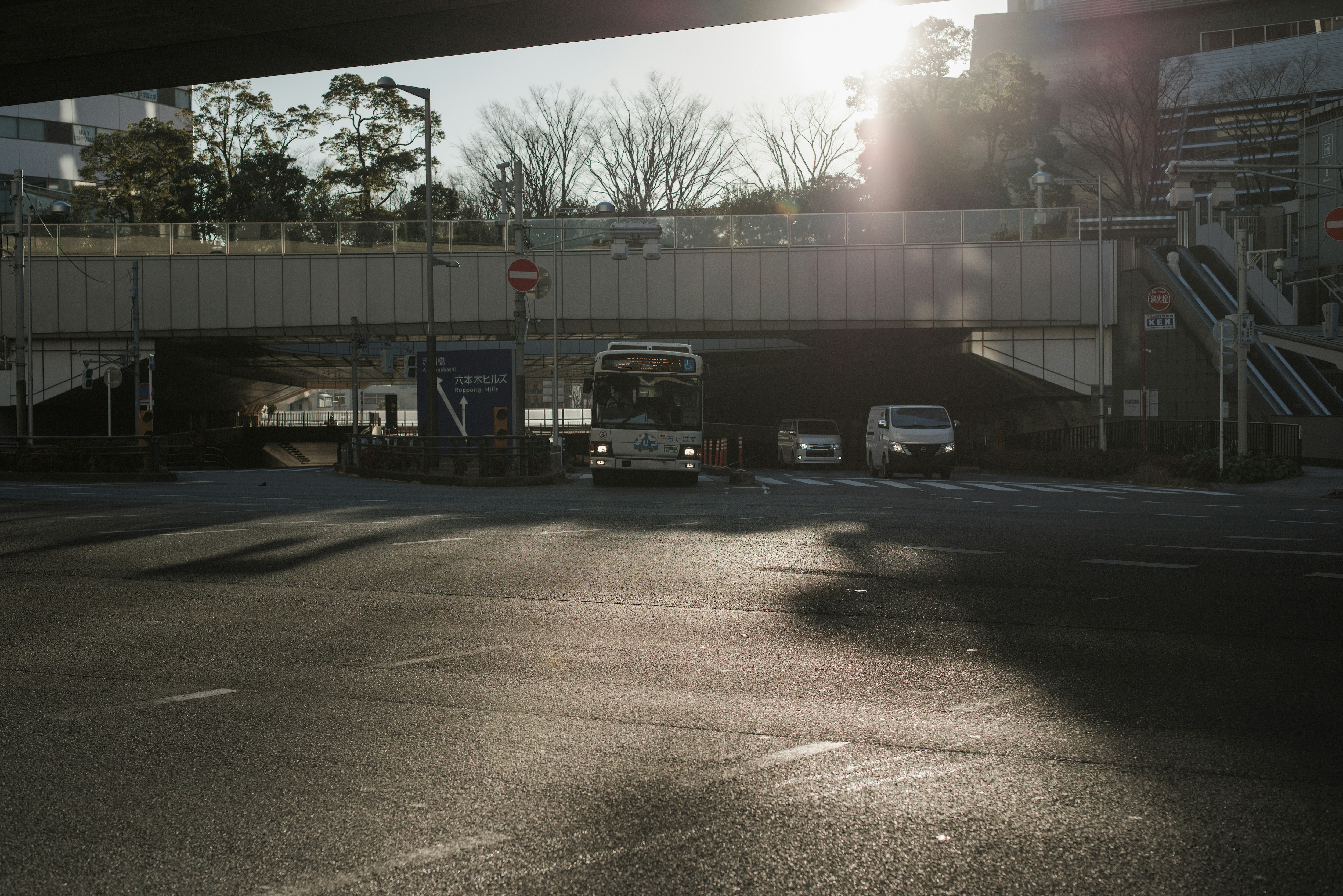 六本木ヒルズ前の交差点を走る車と高架のある都市風景