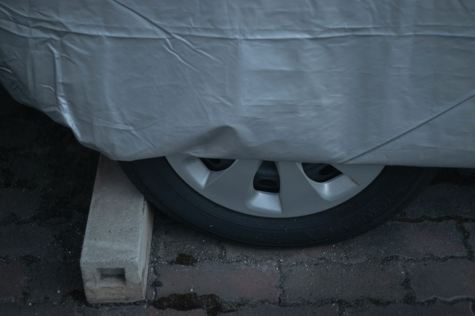 Pneu de voiture reposant sur un bloc de bois avec une couverture