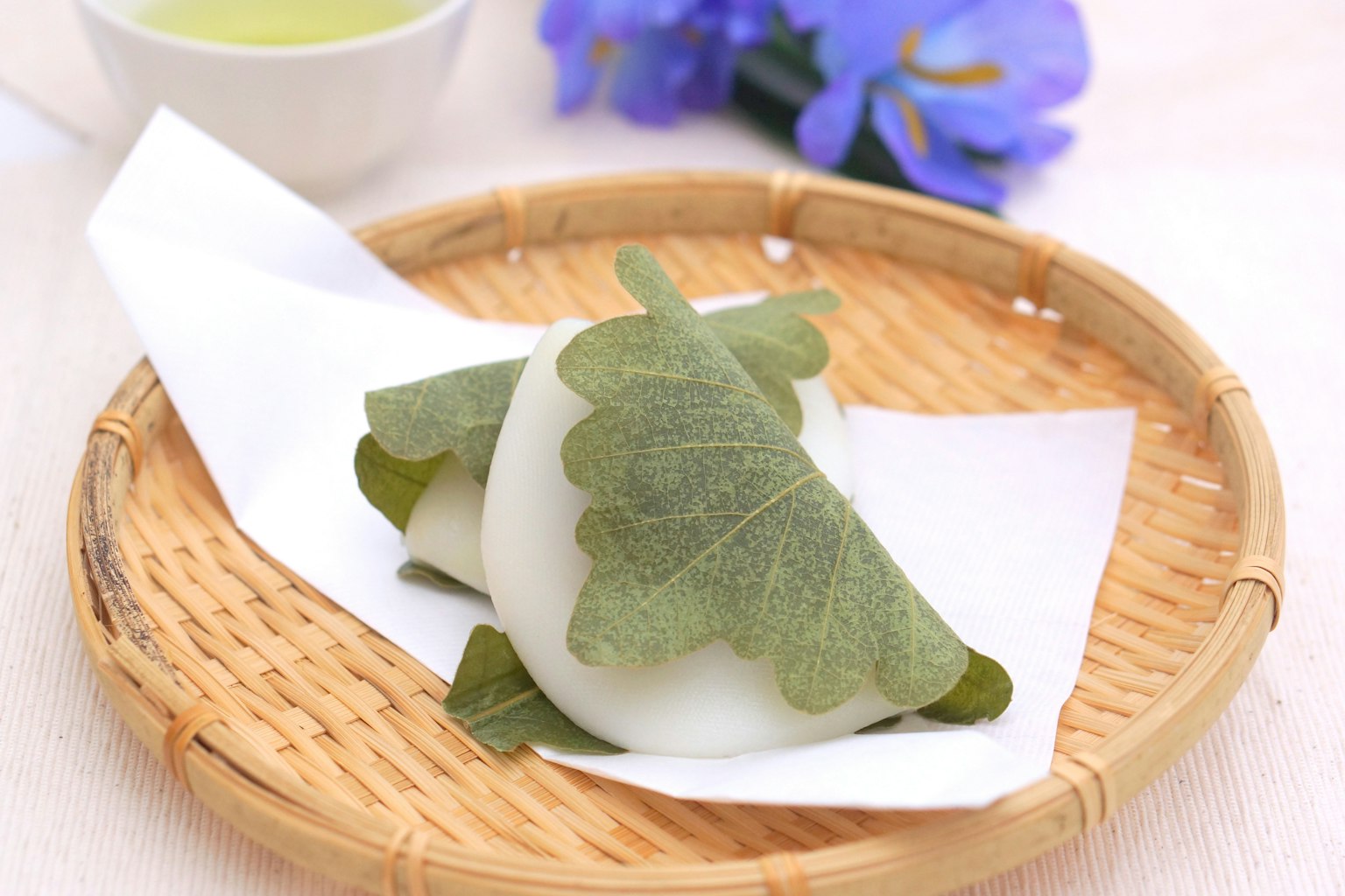 Dulces japoneses envueltos en hojas en un plato de bambú
