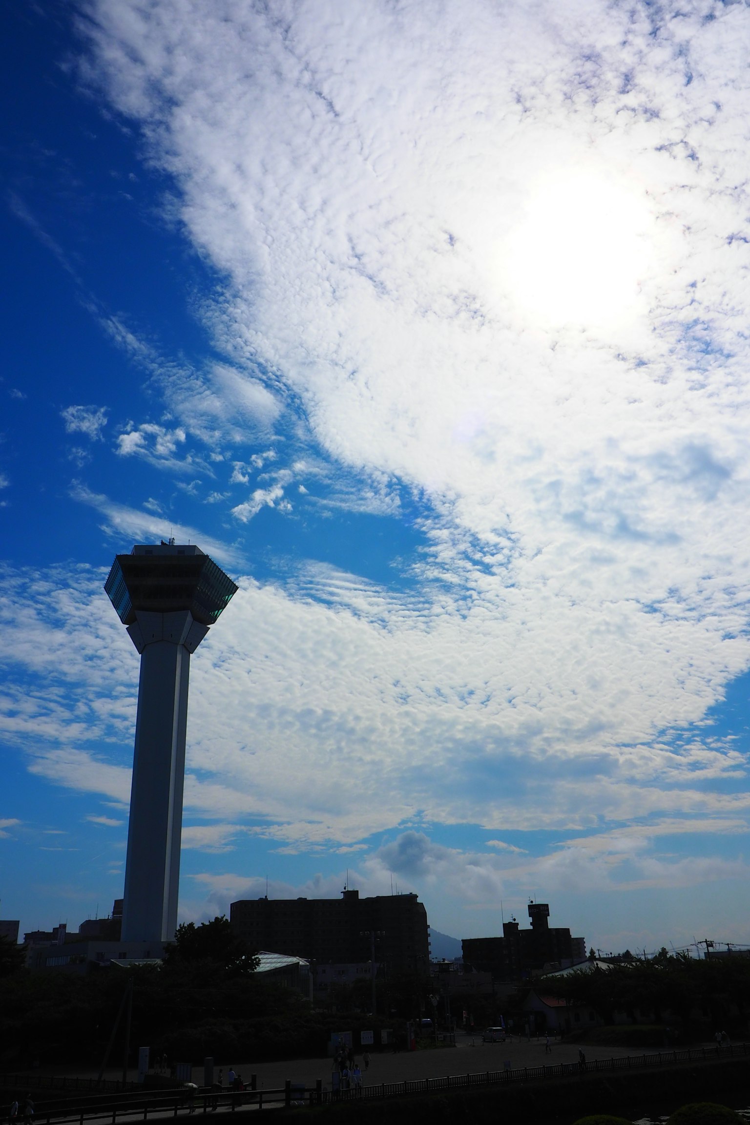 Silhouette menara di bawah langit biru dengan awan