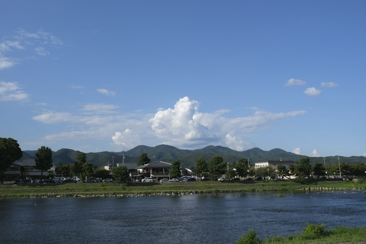 Vista escénica con cielo azul y nubes blancas río y montañas