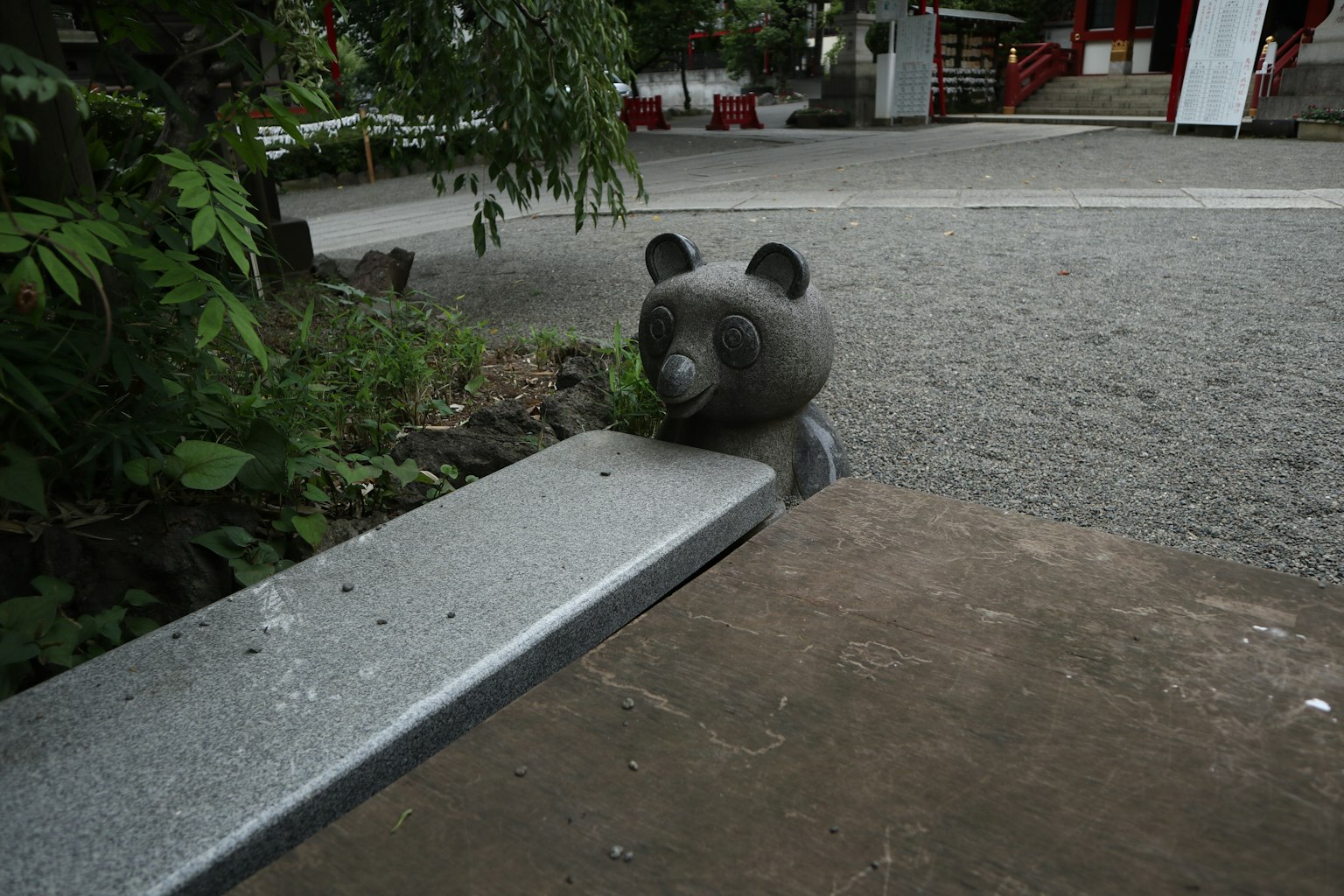 Patung panda di bangku taman dikelilingi pepohonan