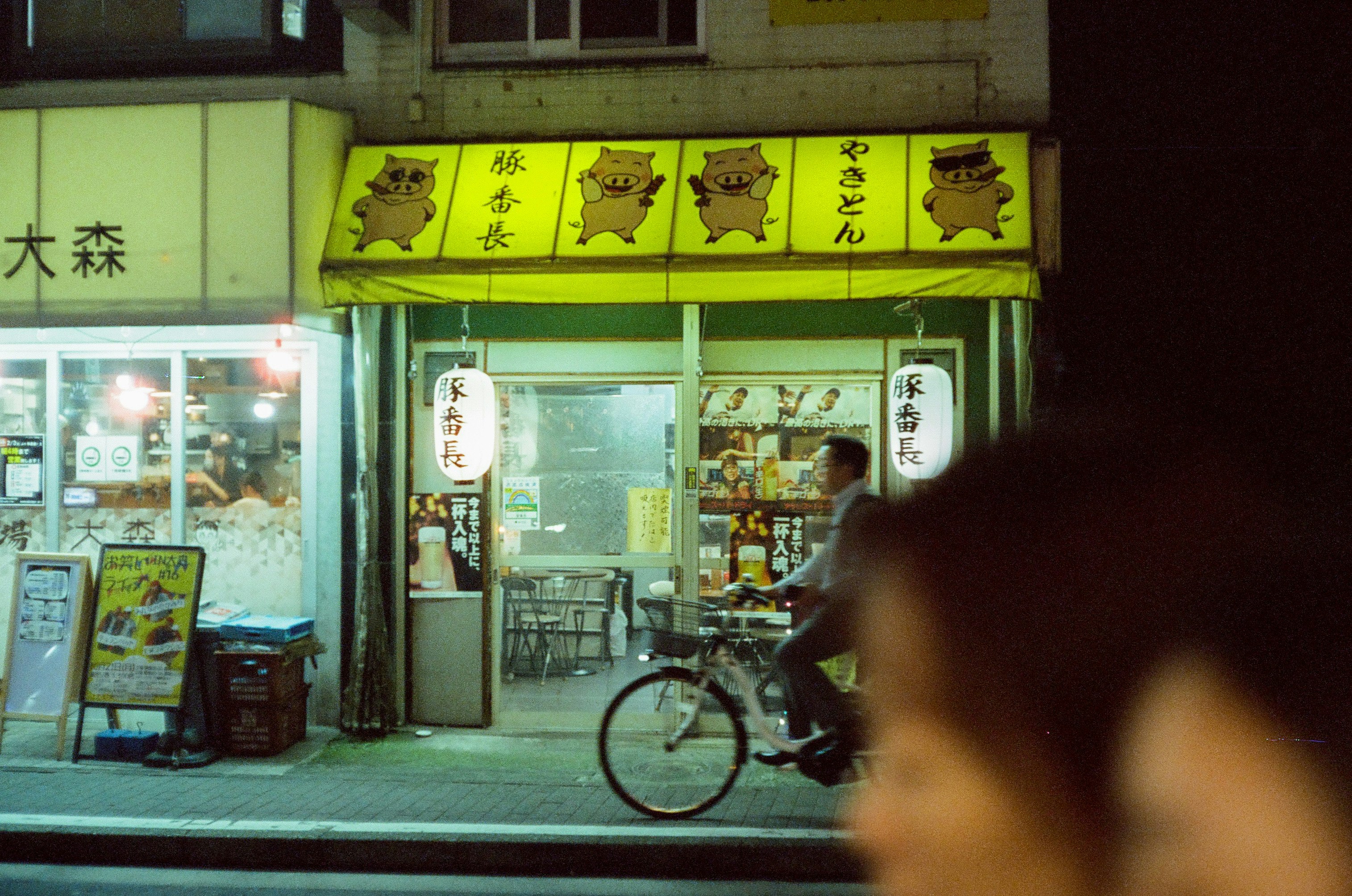 路地の店先に自転車が停まる夜の商店街