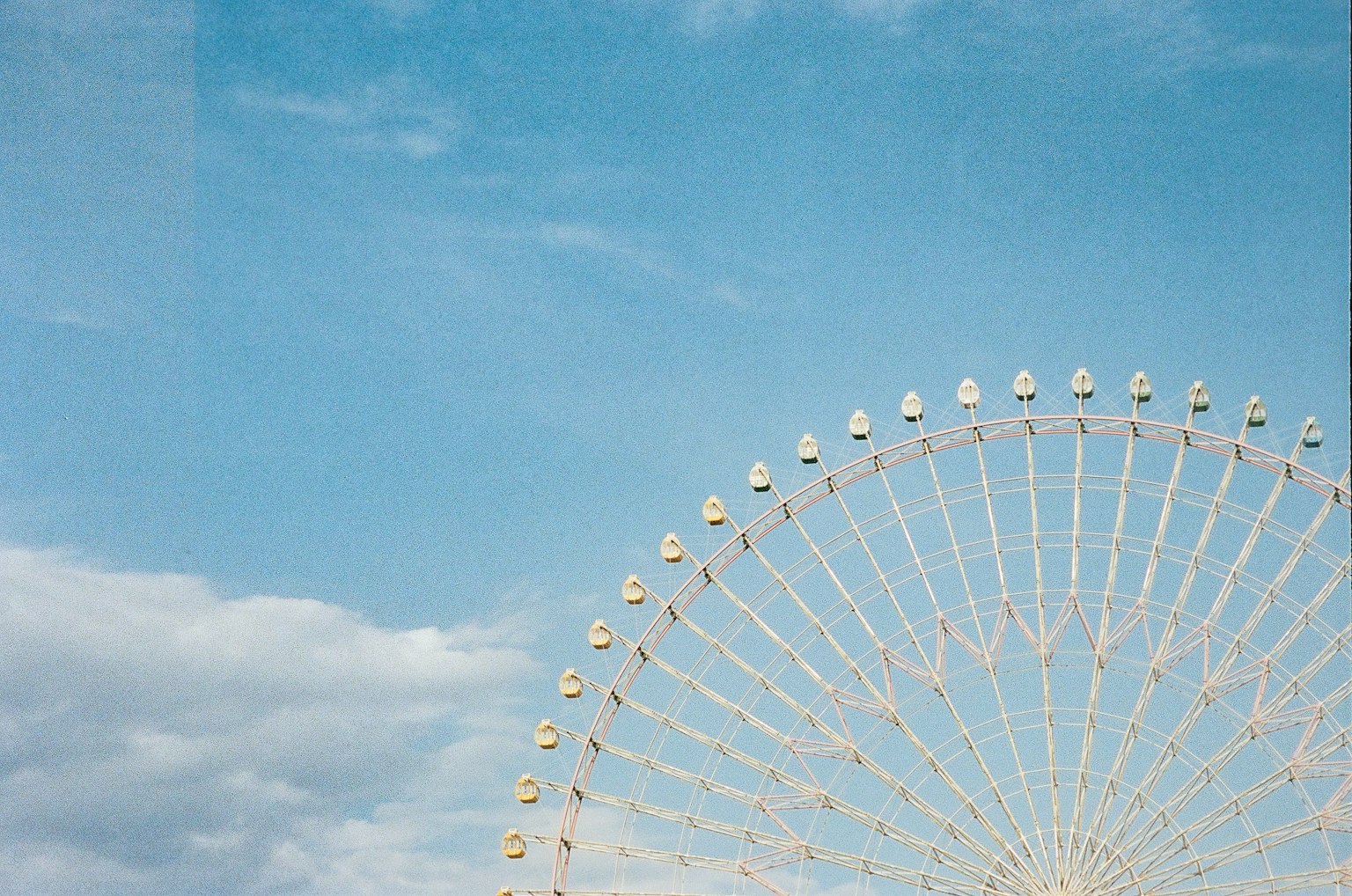 Vue partielle d'une grande roue sous un ciel bleu
