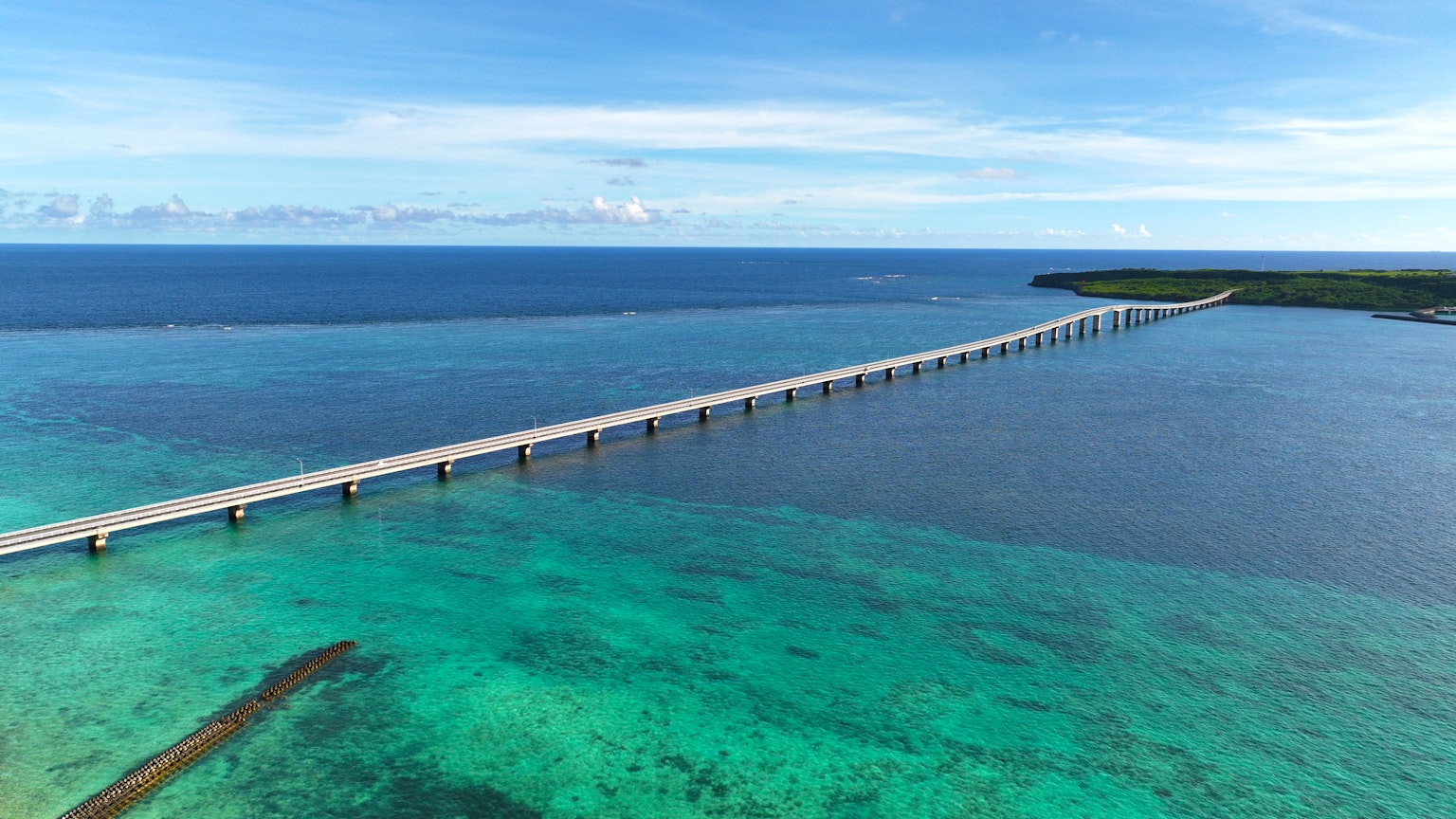 Vista aérea de un puente largo sobre aguas turquesas