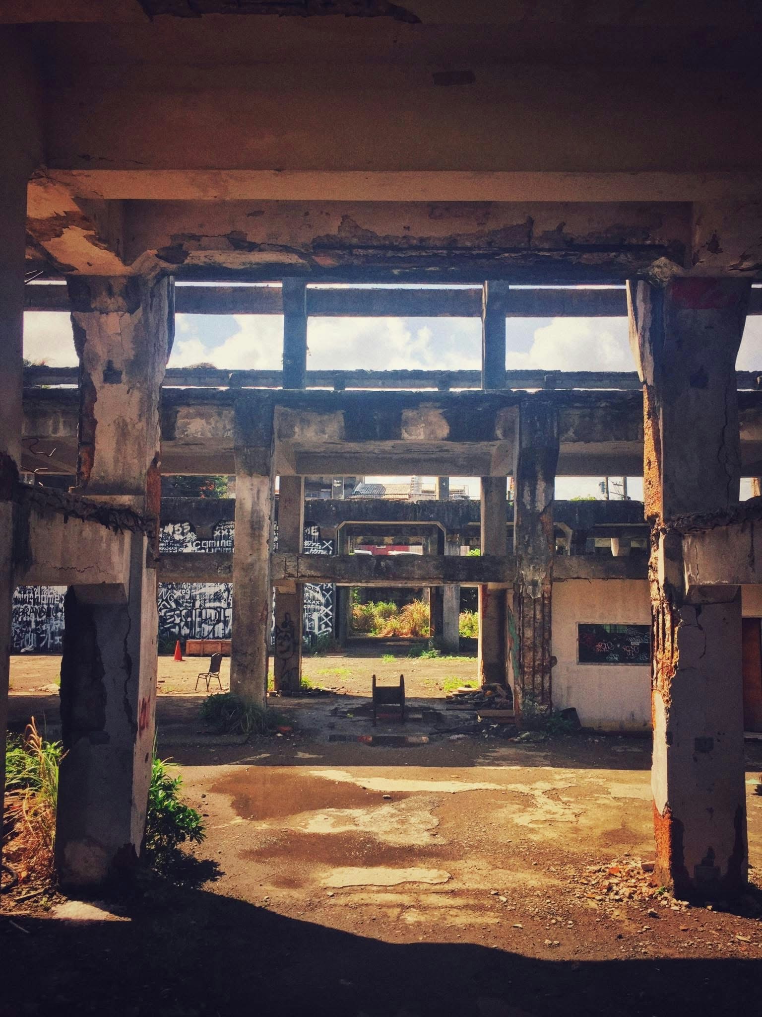 廃墟のような建物の開口部から見える中庭の風景
