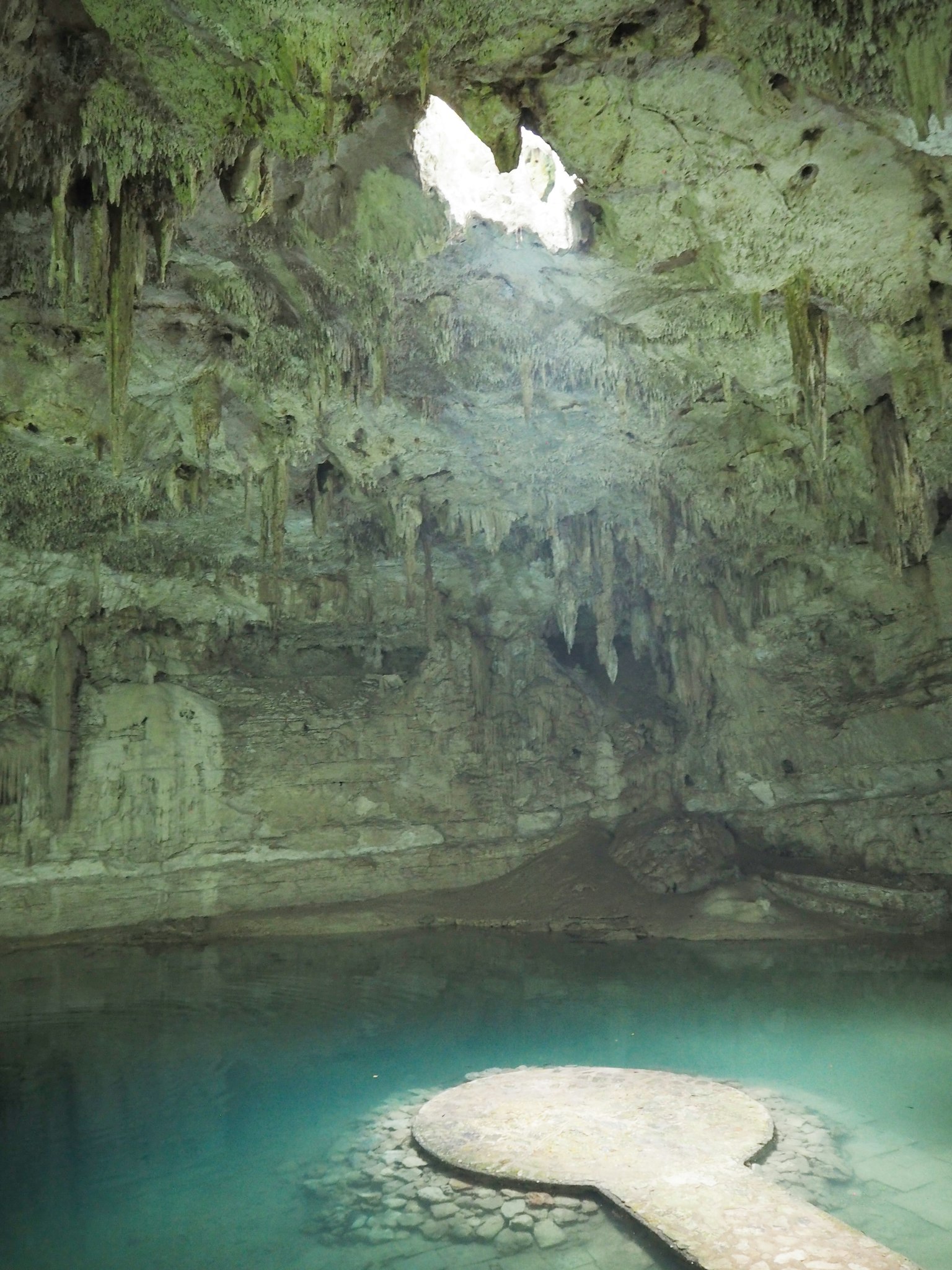 Intérieur de grotte mystérieuse avec piscine d'eau bleue et lumière qui pénètre