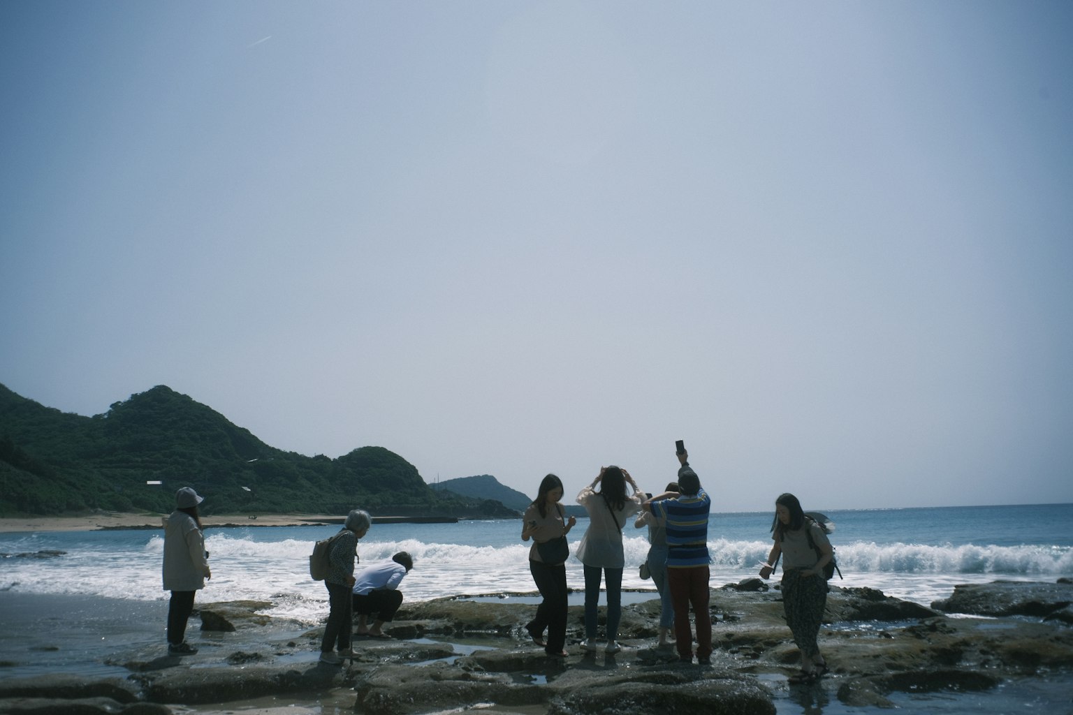 一群人探索岩石海滩与海洋波浪