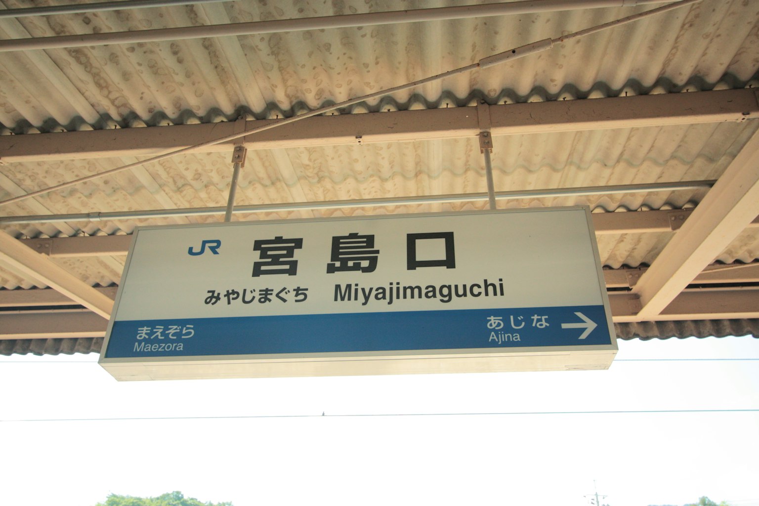 Cartel de la estación Miyajimaguchi con texto en japonés y romaji