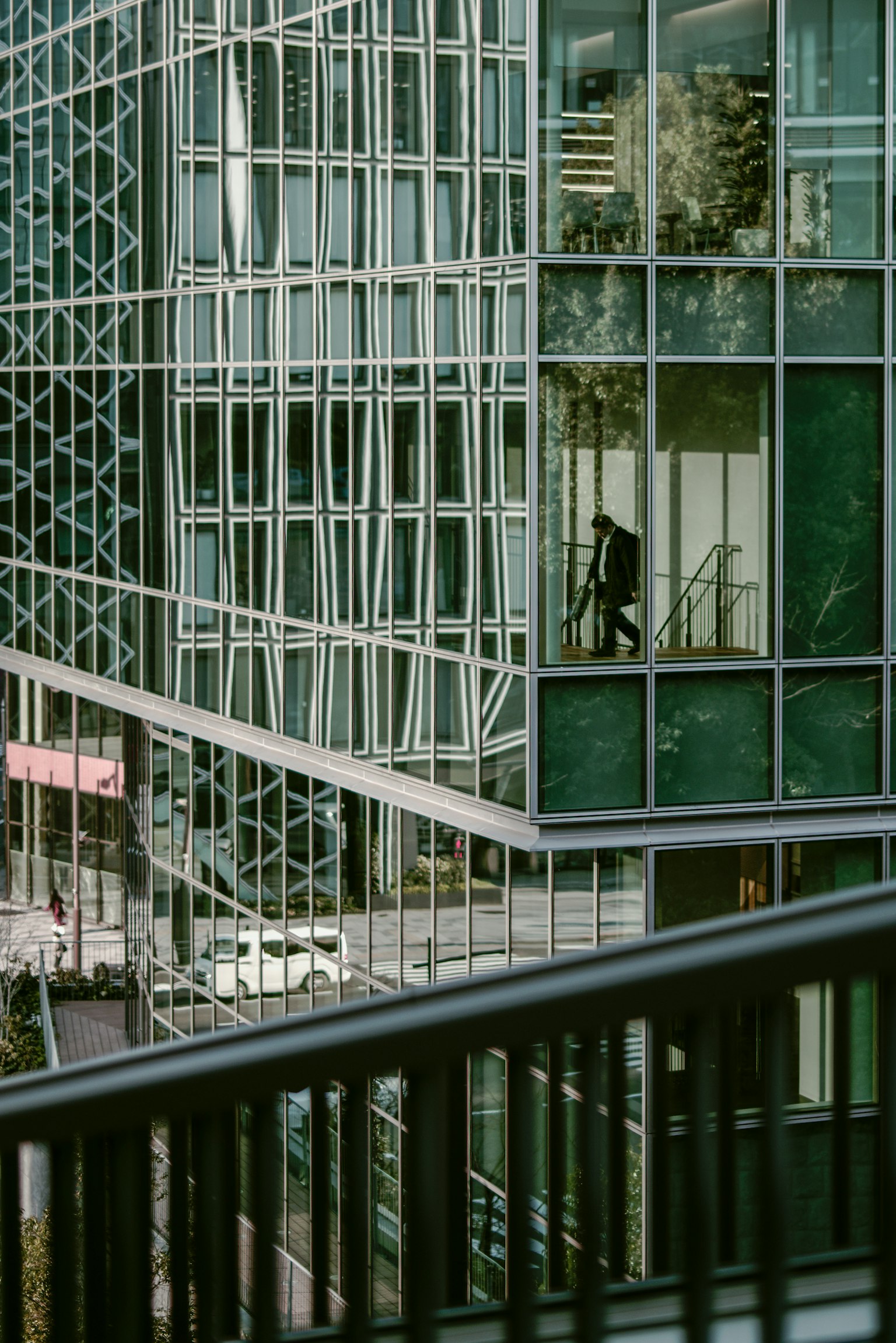 Tòa nhà văn phòng hiện đại với mặt tiền kính và phong cảnh phản chiếu