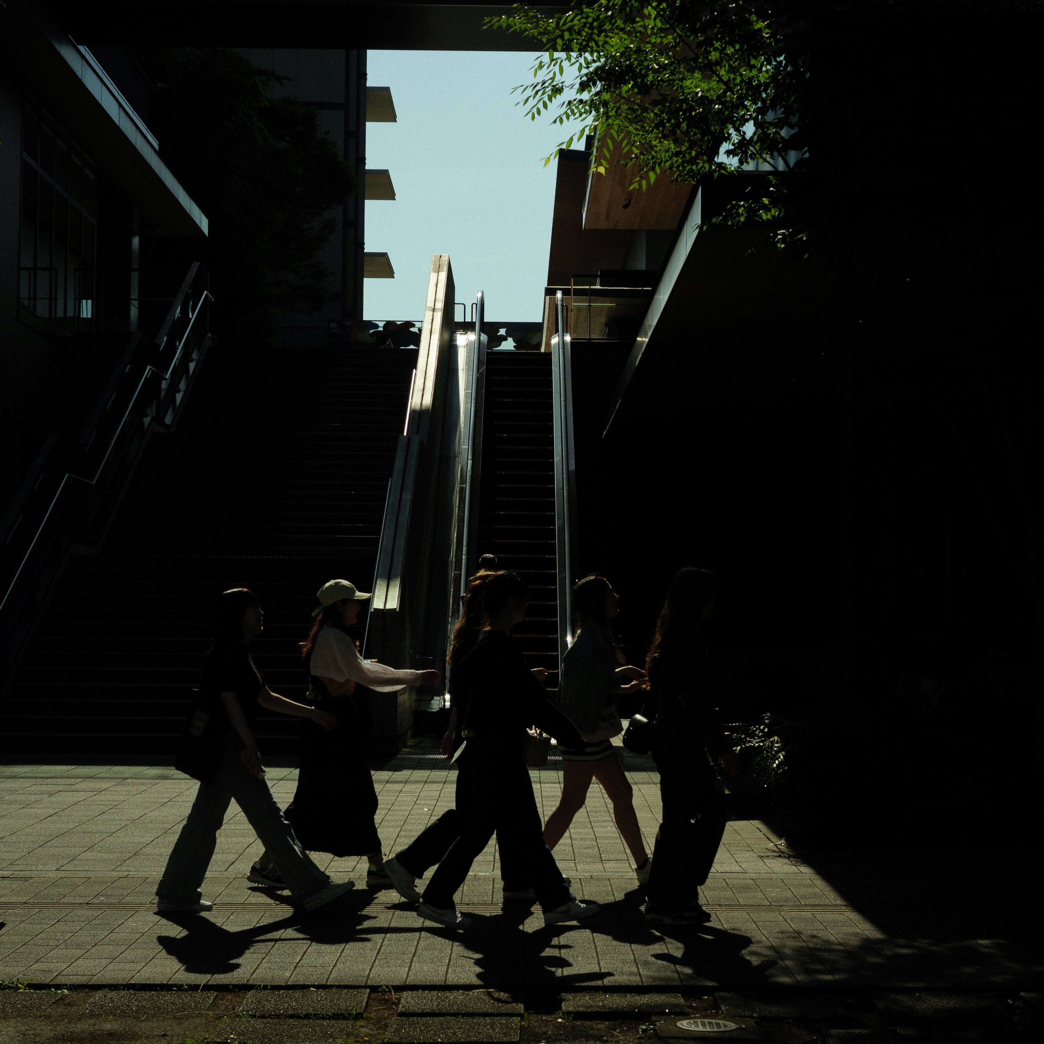 street snapshot of young women walking past a stairway in an alley