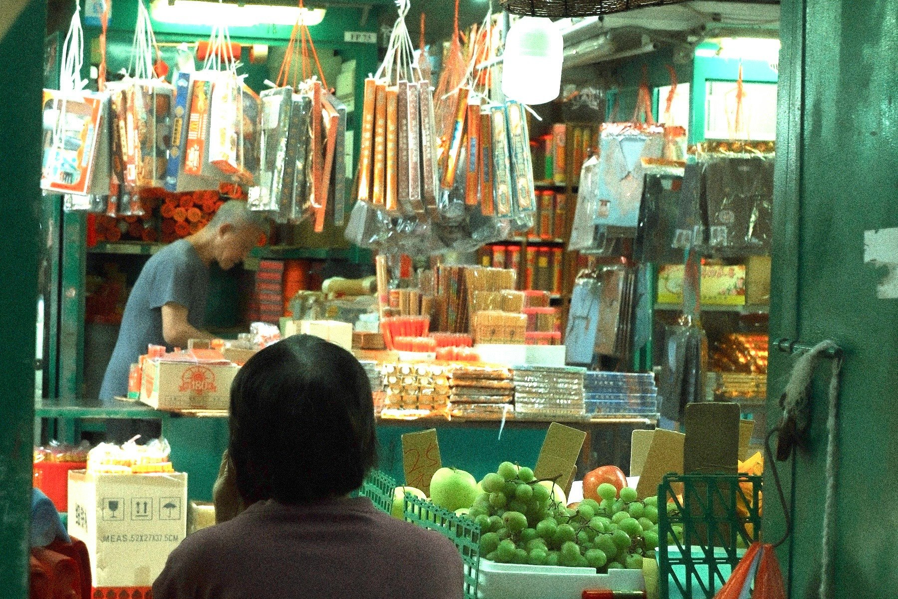 snack stall storefront with green fruit and hanging goods