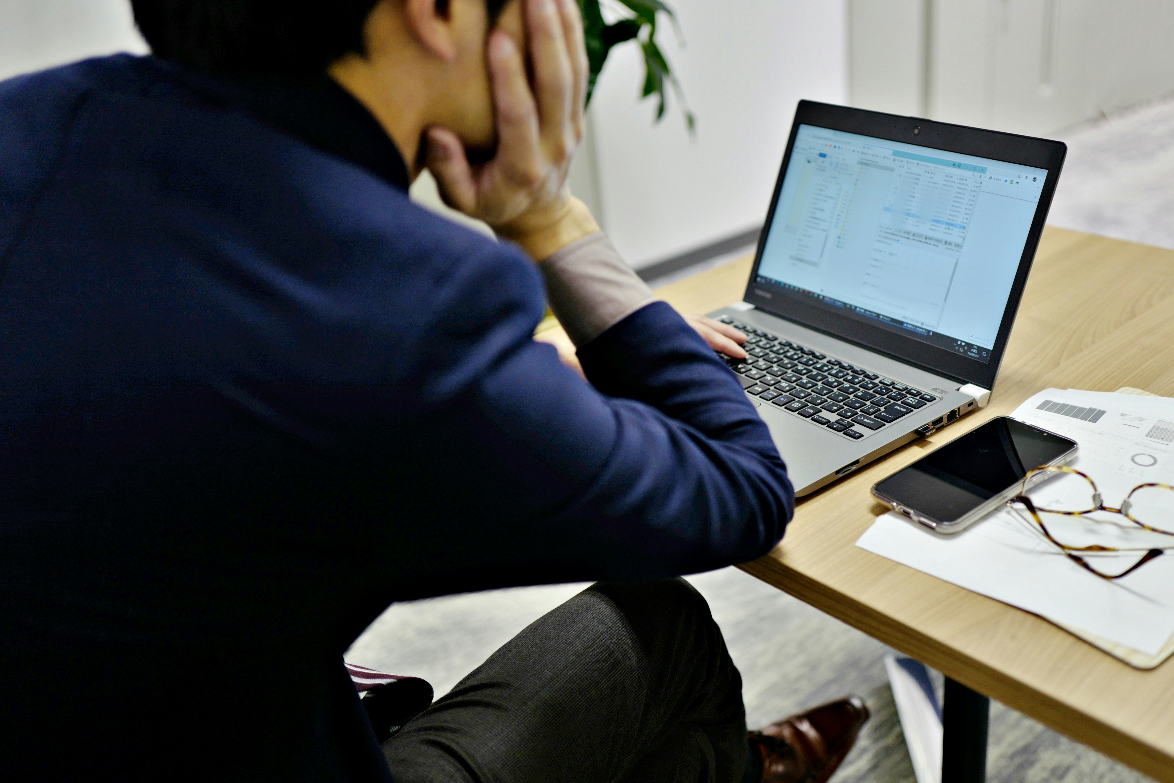 side view of a person working on a laptop