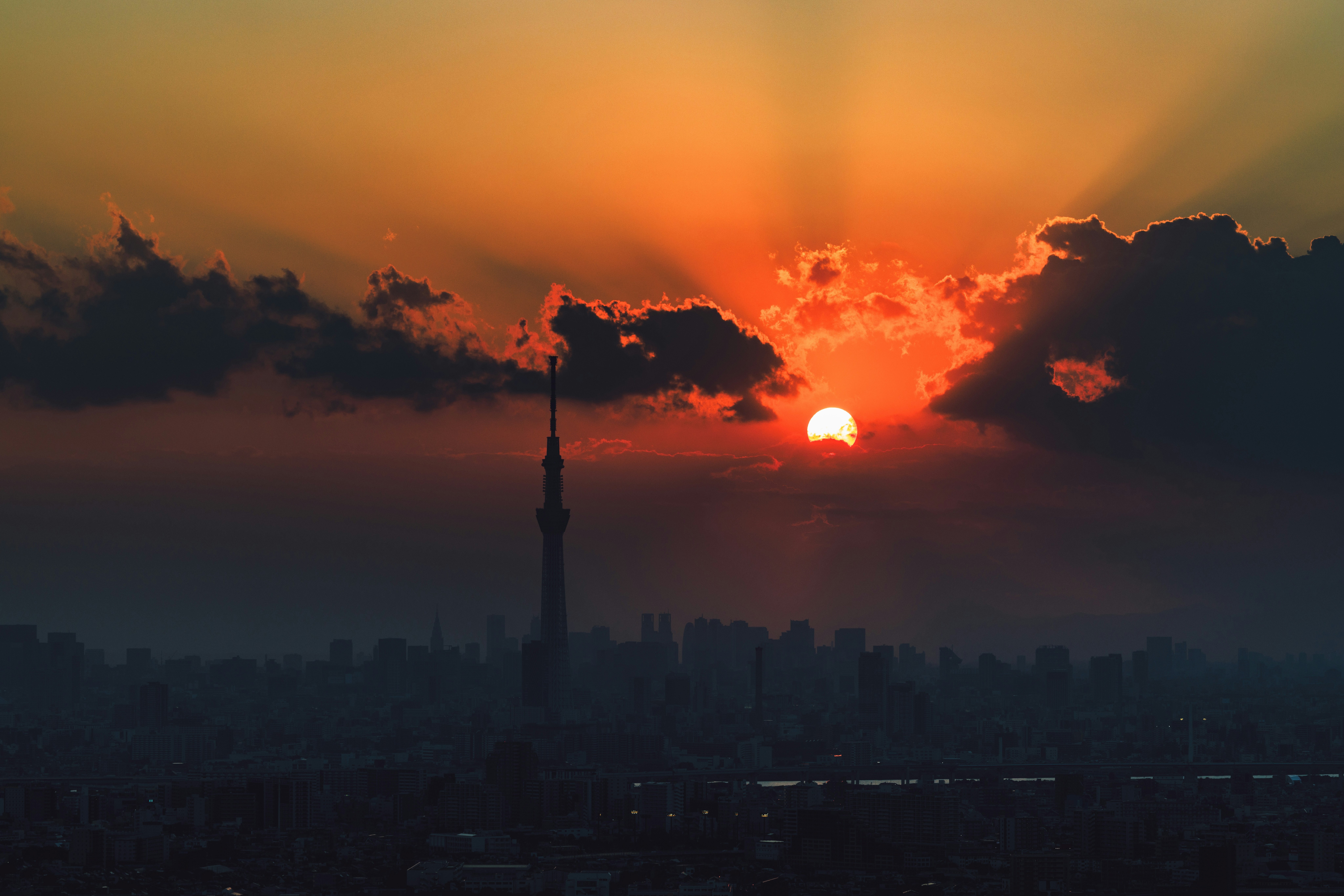 夕陽に照らされた雲と街並み、シルエットの塔