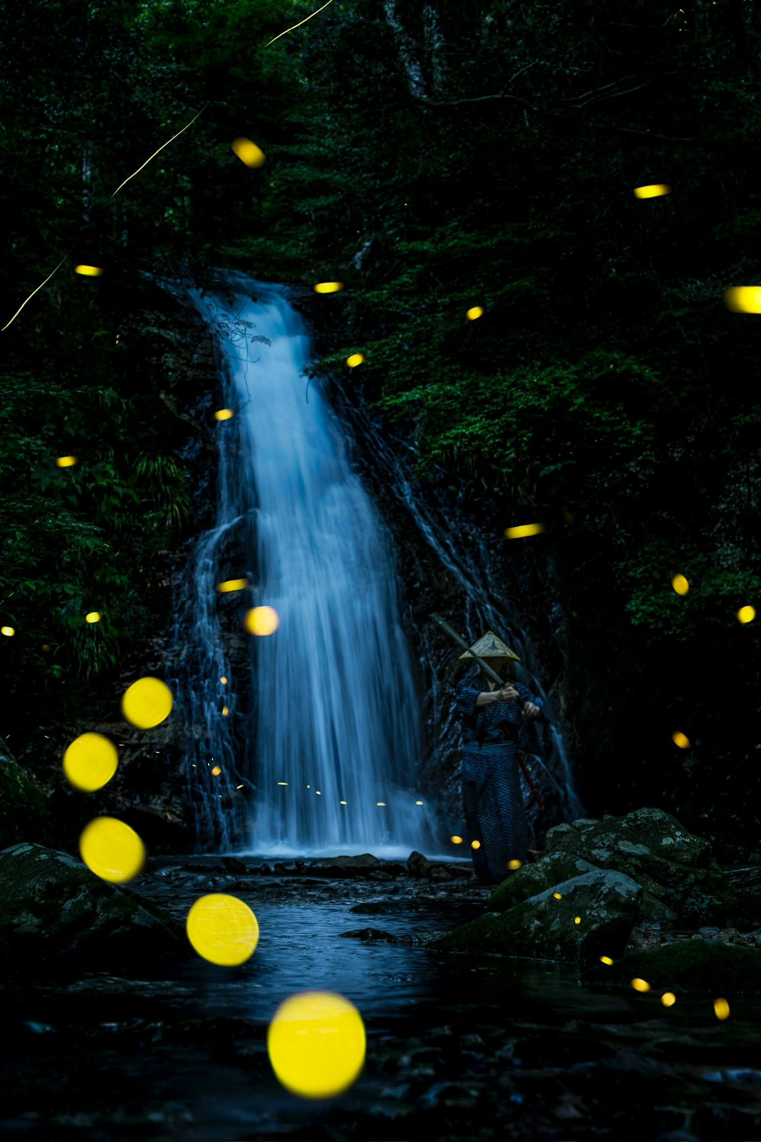 瀑布前飞舞的萤火虫的梦幻场景