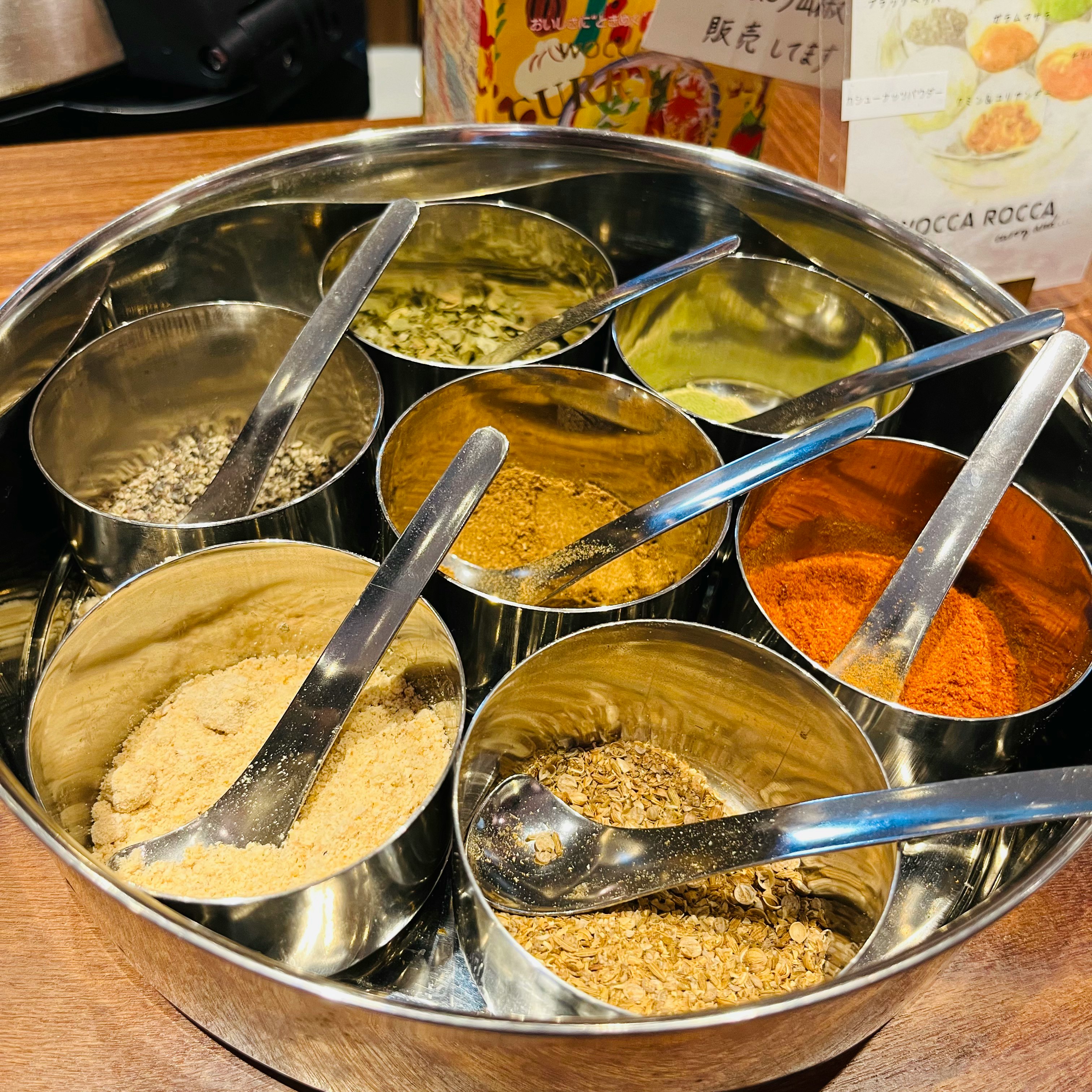 スパイスの色と粉末が並ぶカレー用ビュッフェのボウルセット