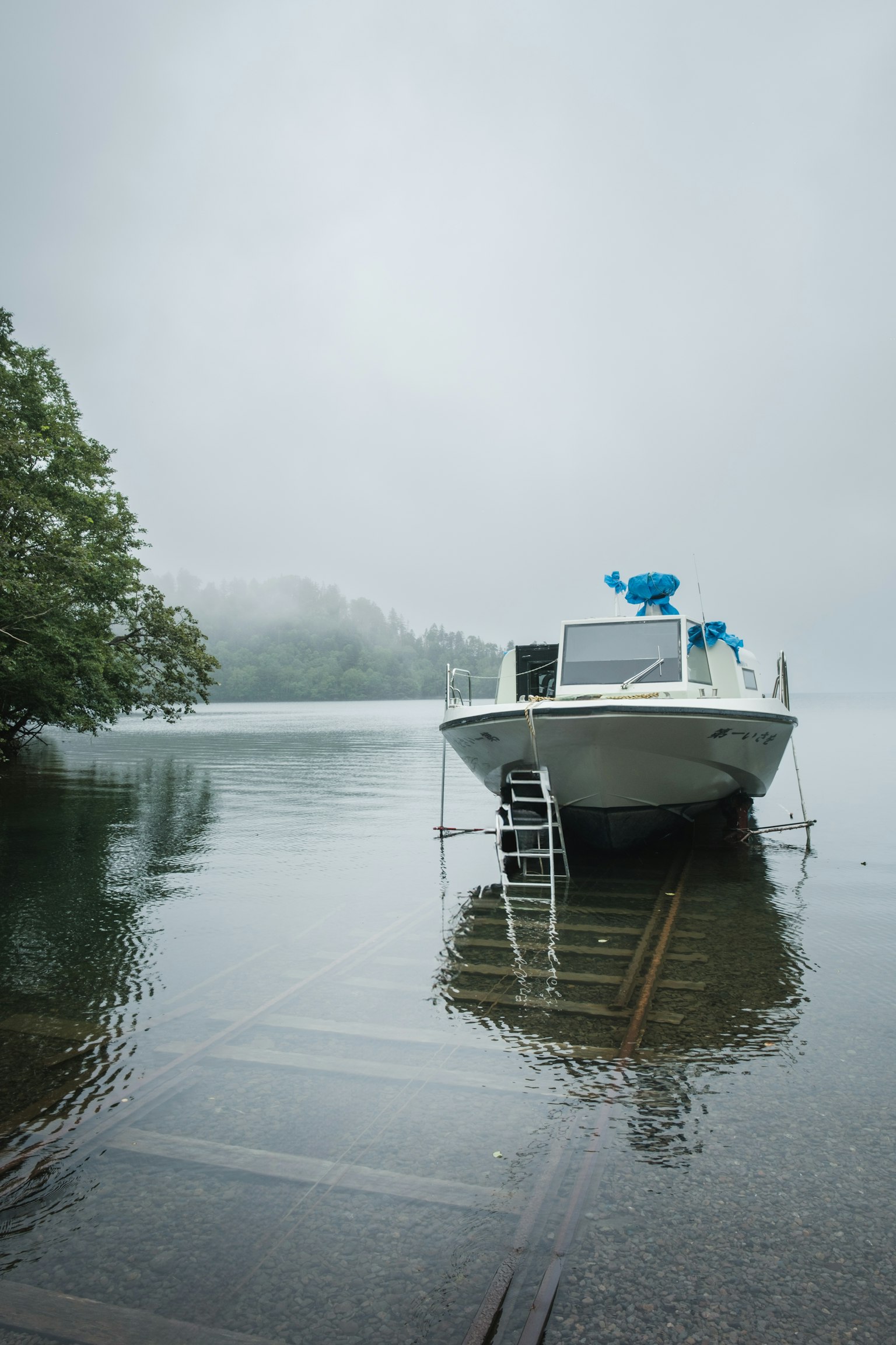 Boat on a tranquil lake surrounded by fog