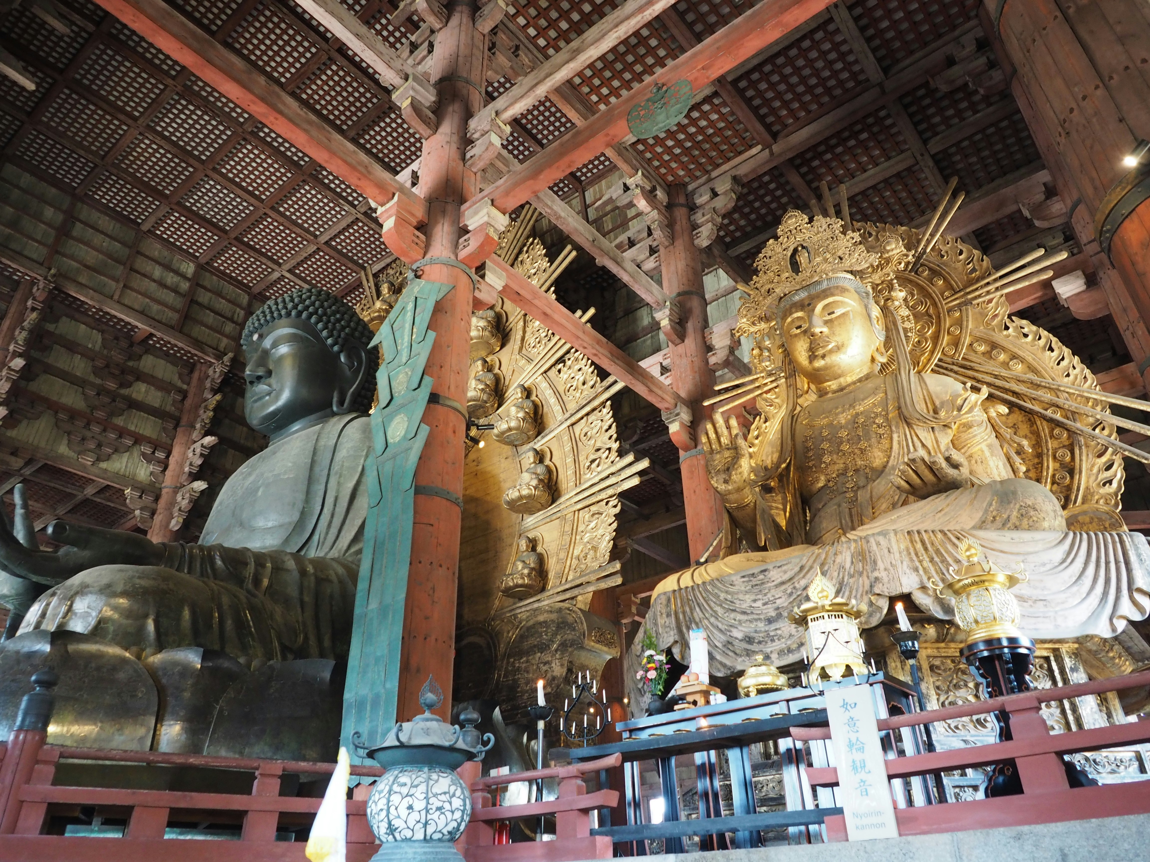 intérieur d’un temple avec un grand Bouddha et une divinité dorée
