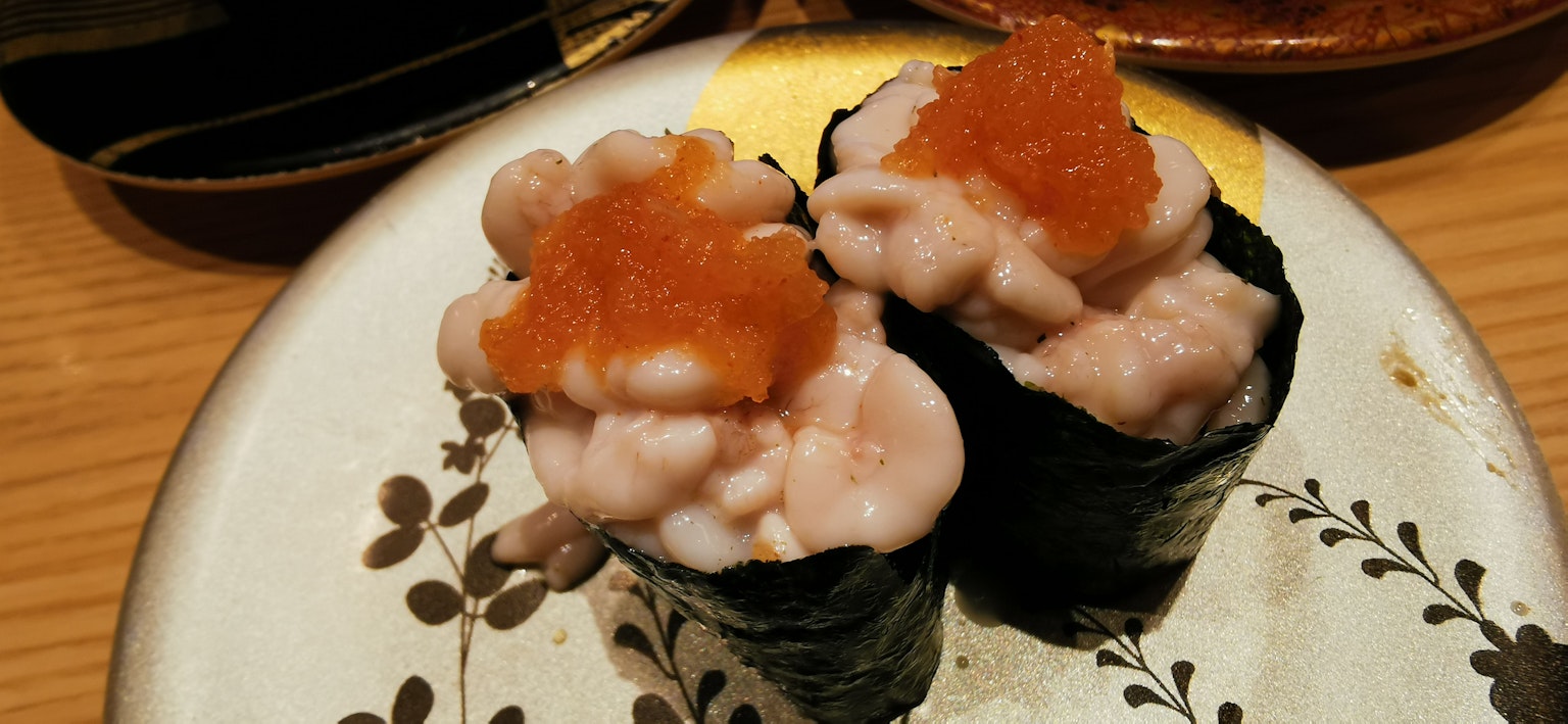 장식적인 접시에 올려진 두 개의 연어 알이 얹힌 스시