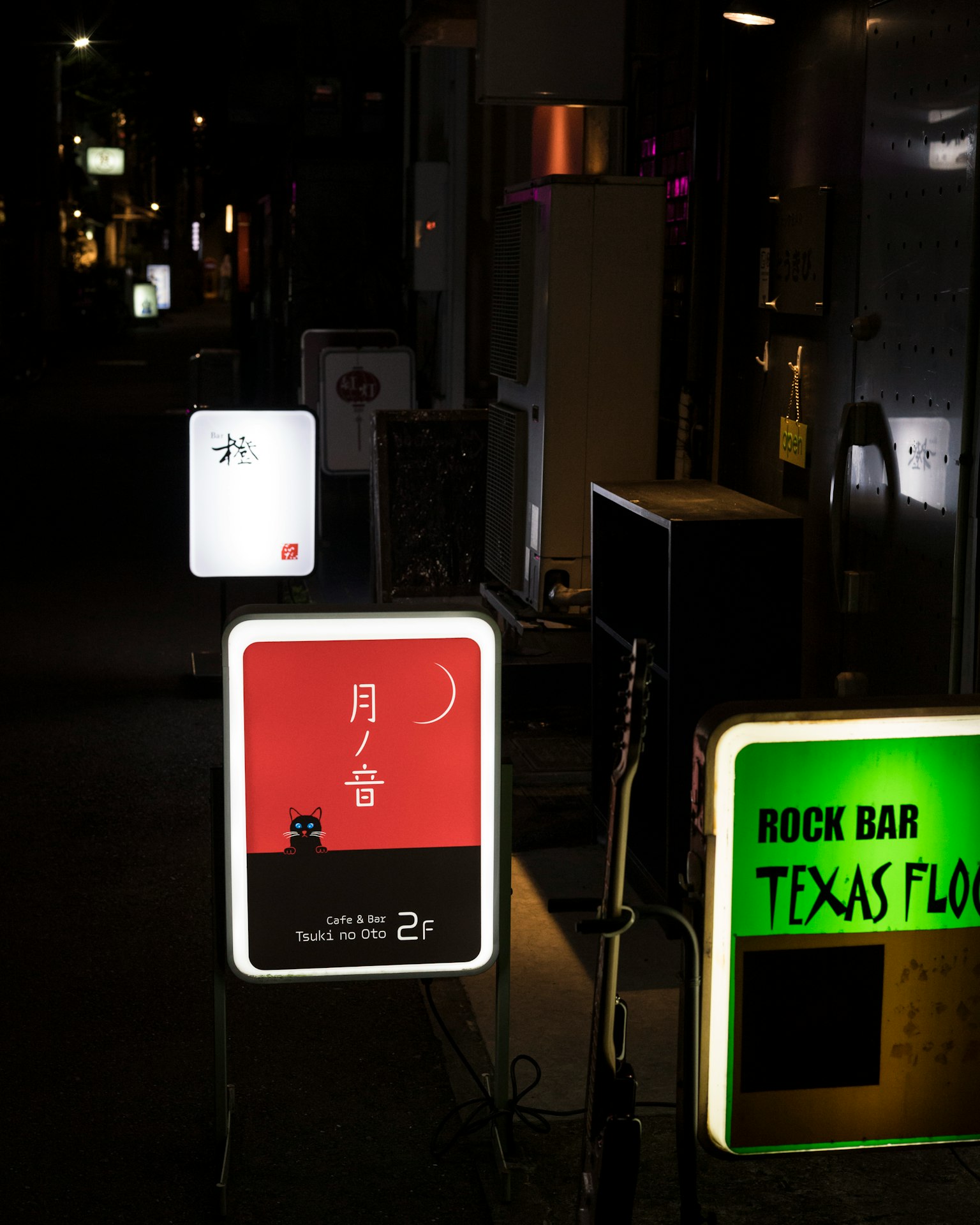 夜の街にあるネオン看板が並ぶ通りの風景