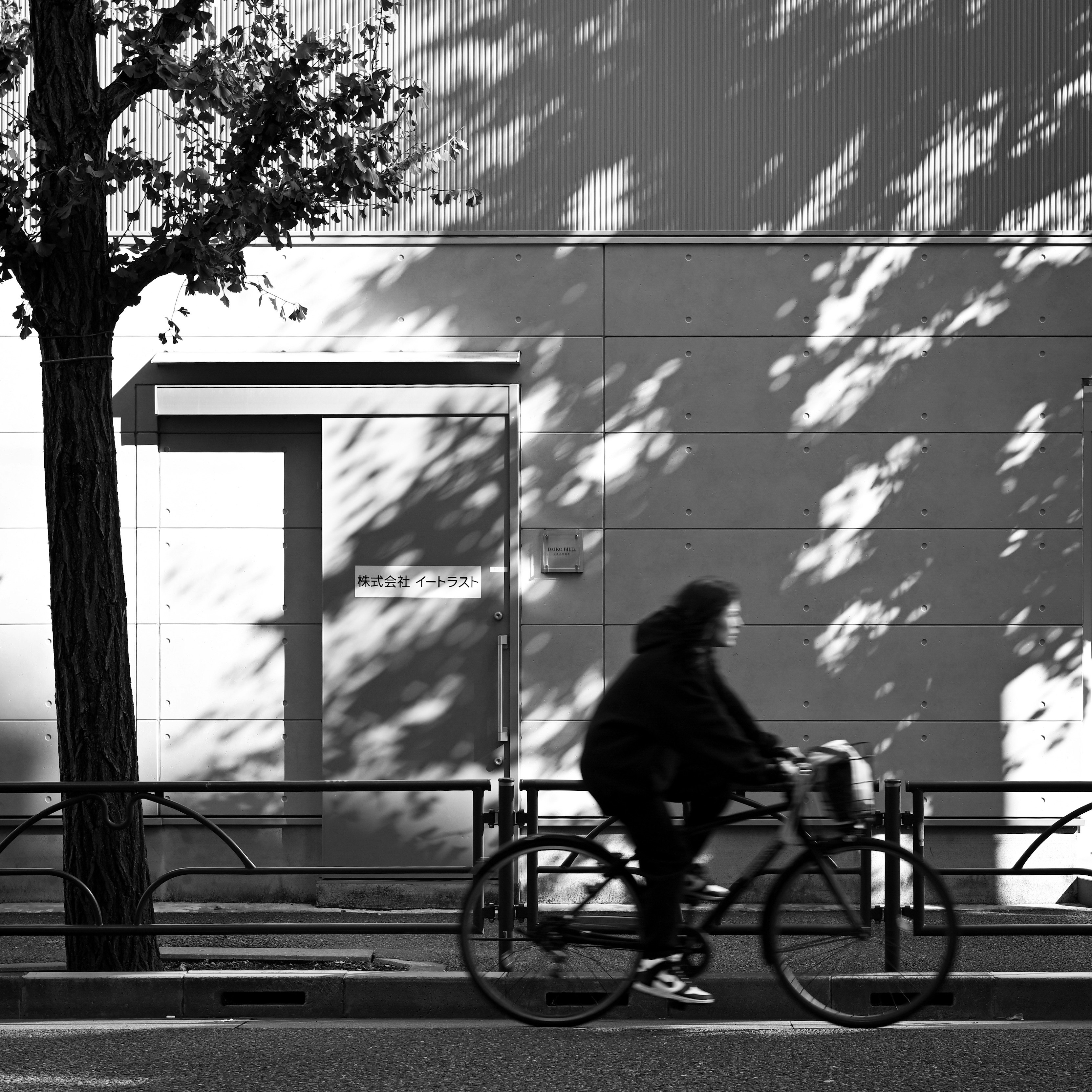 東京の路上を疾走する自転車のモノクロ残像