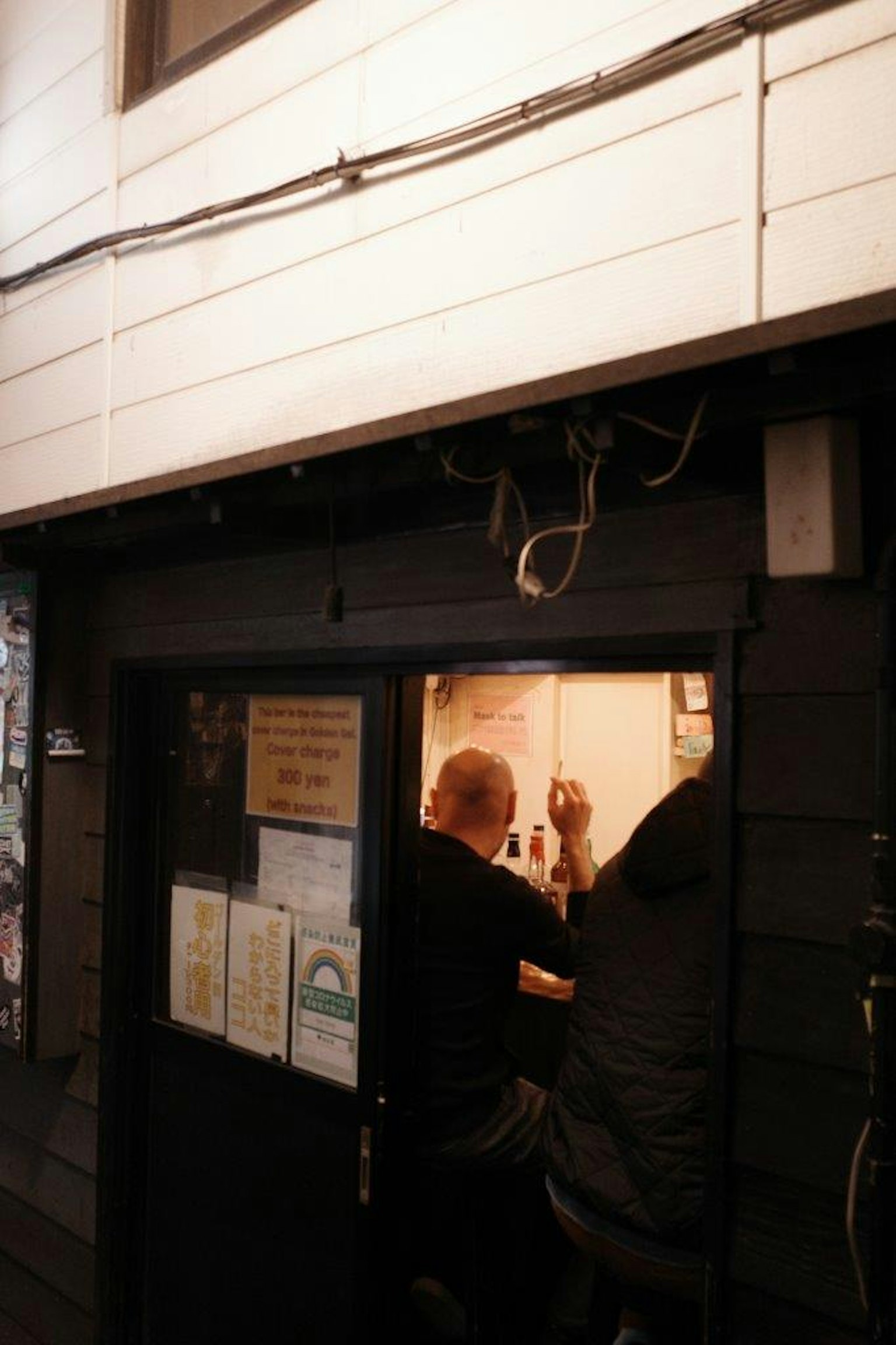 兩個人坐在昏暗商店的櫃檯上