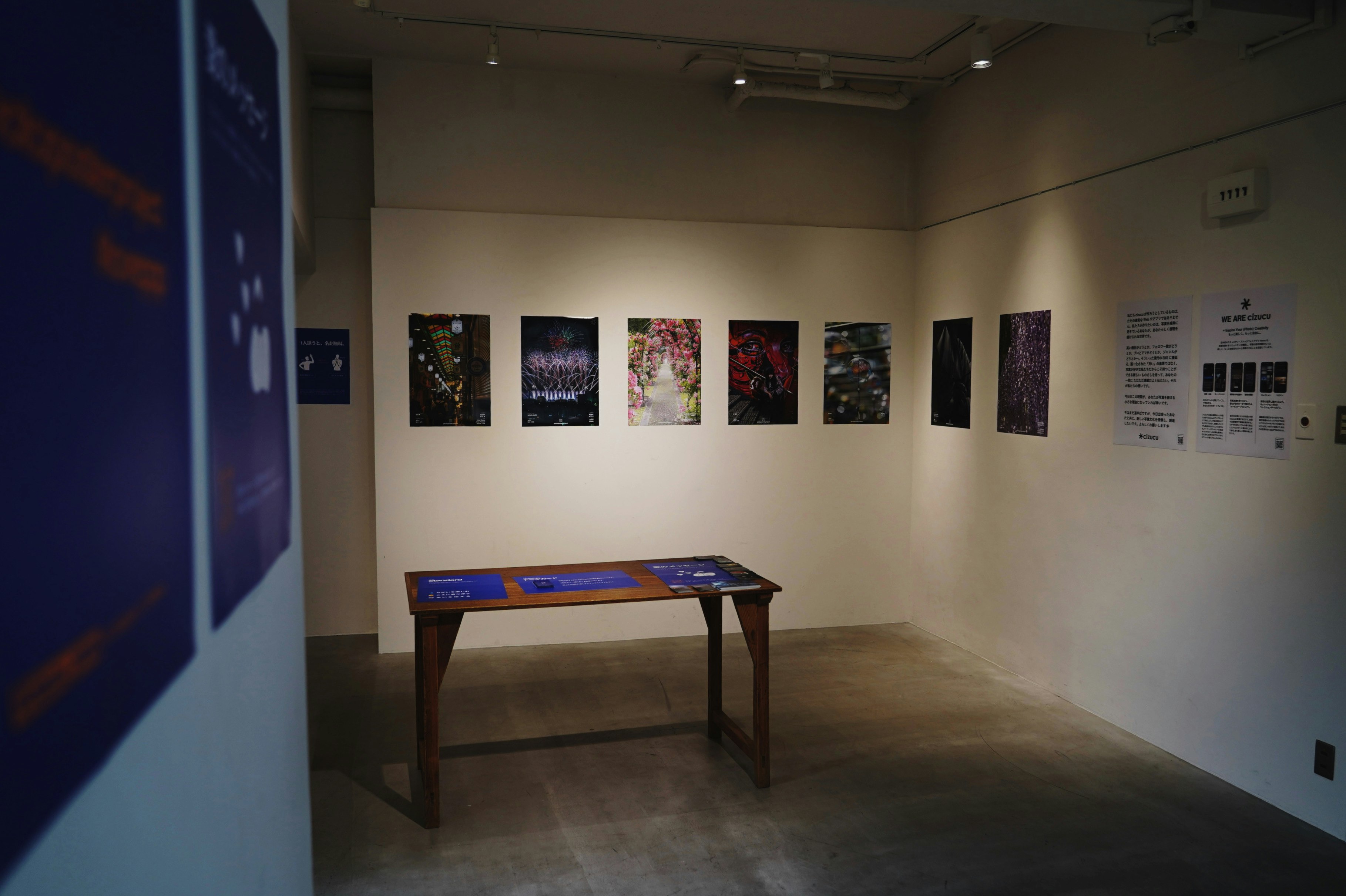 bức tường phòng trưng bày ở Kyoto với các poster ảnh được trưng bày và bàn trưng bày