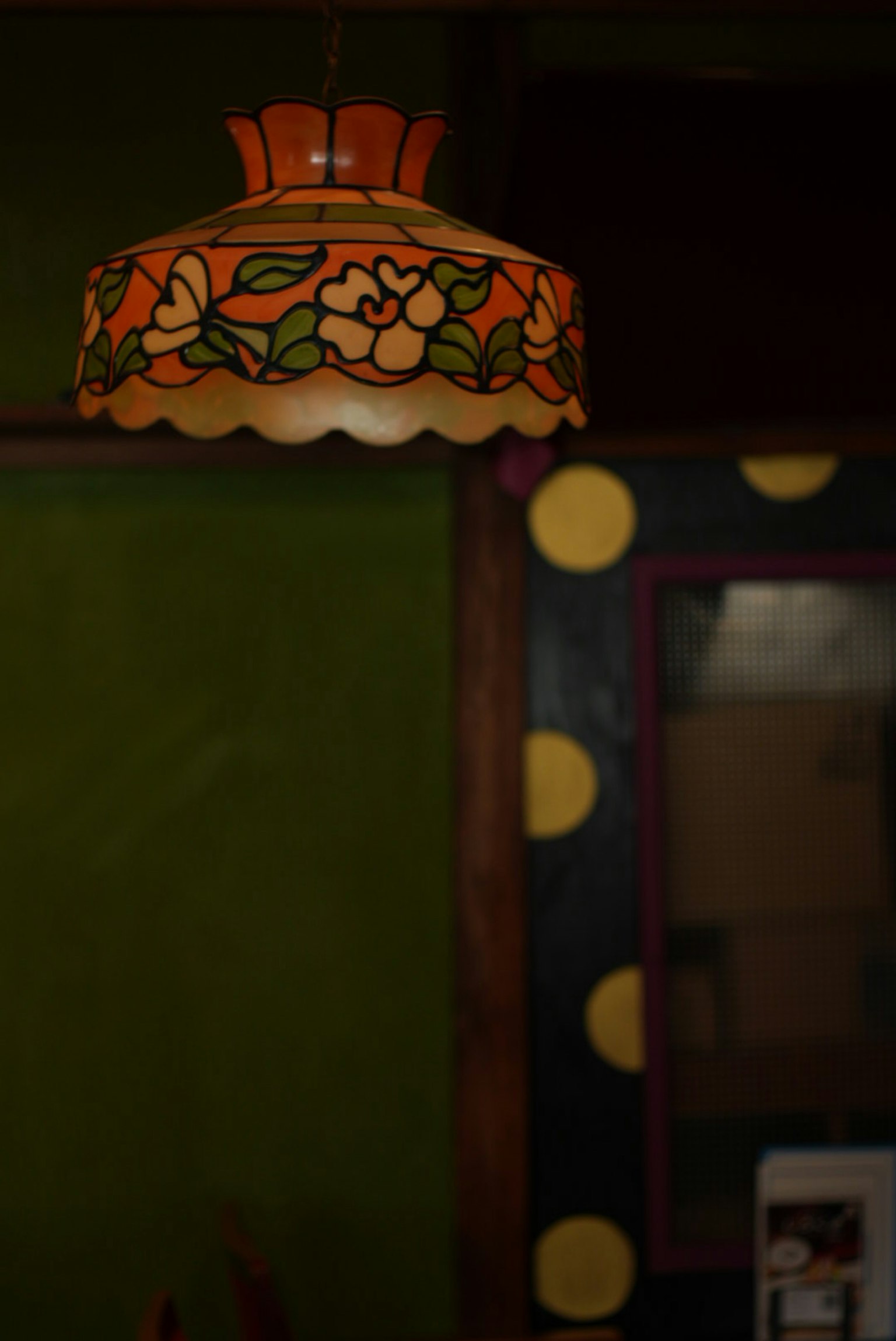 Bunte, blumenmuster Lampenschirm, der in einer Ecke eines Raumes hängt