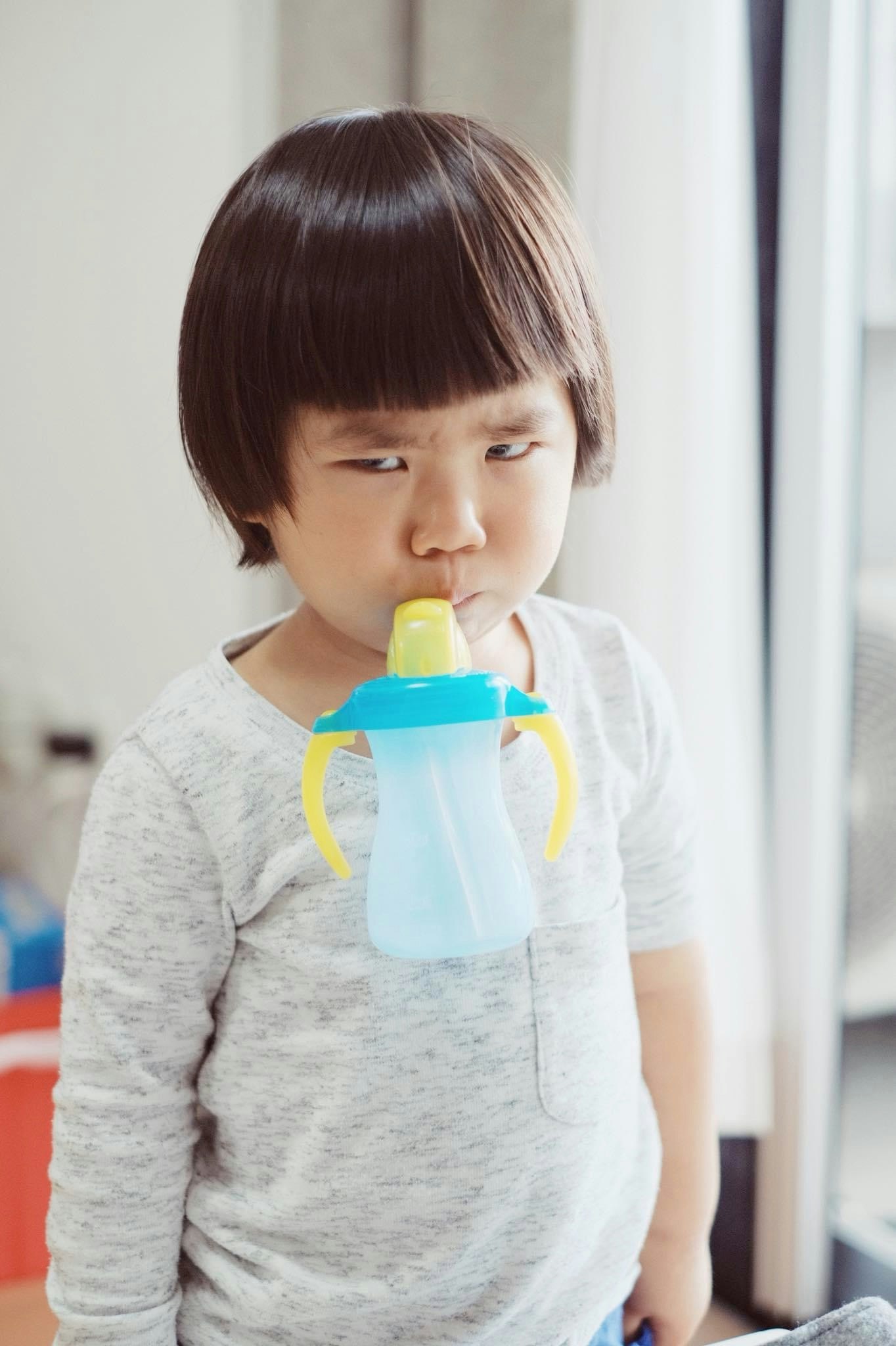 哺乳びんを持つ子どもの横顔