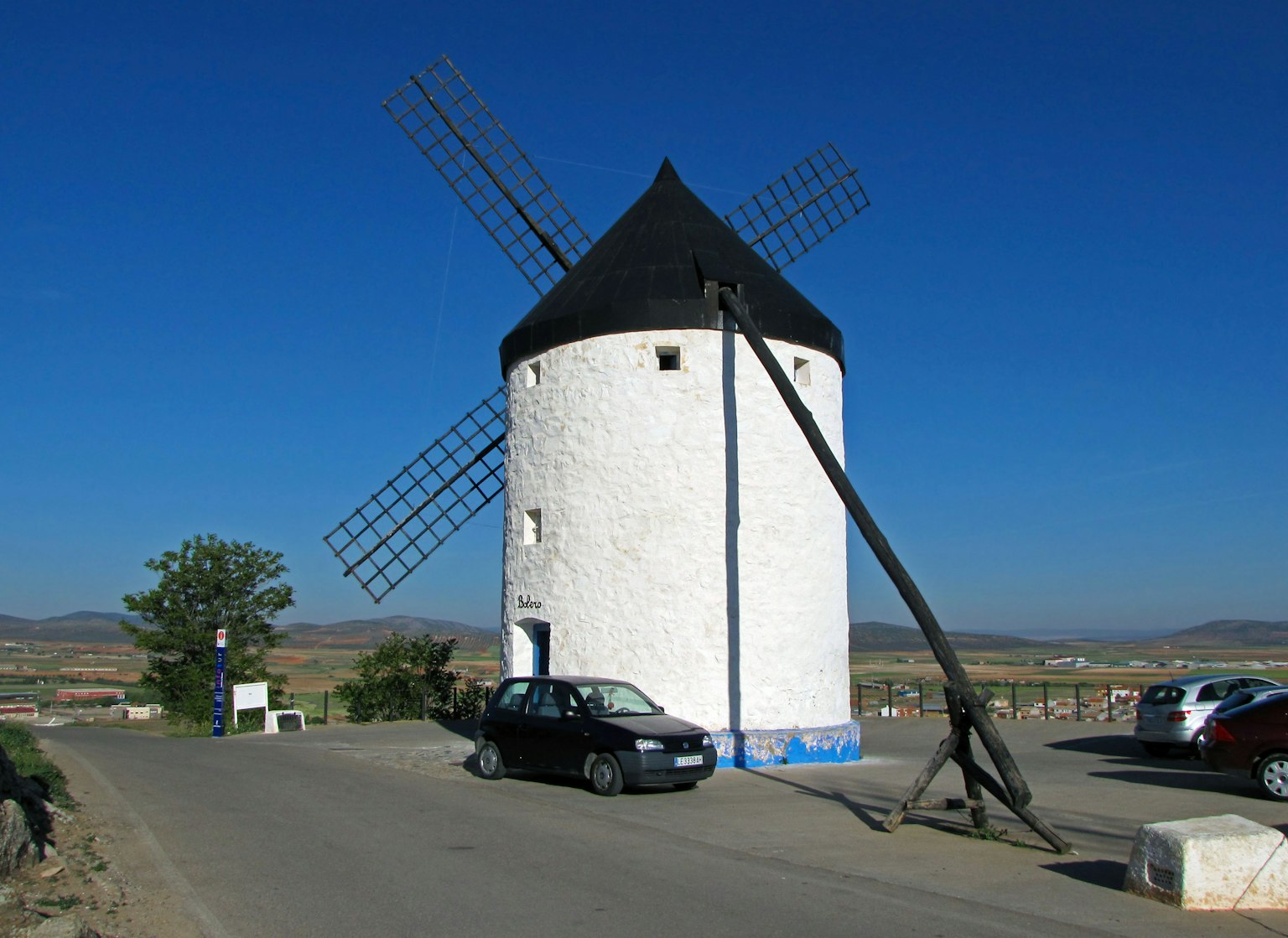 Tour de moulin blanc avec un toit noir sous un ciel bleu
