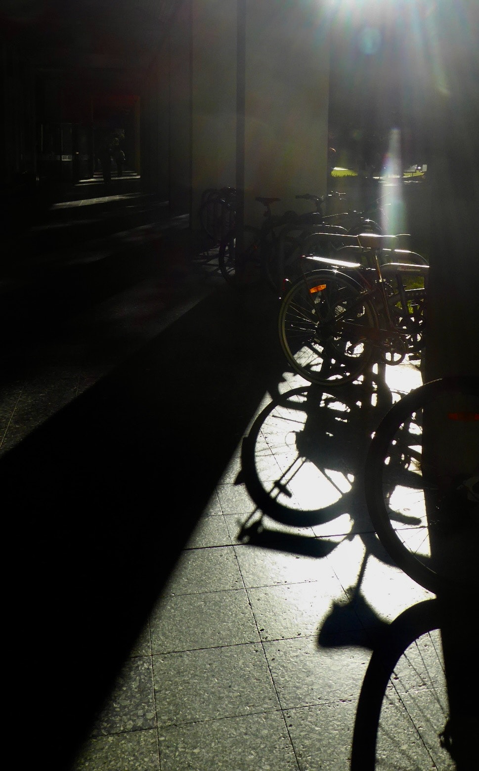 光の差す路地の自転車影と街灯のある夜の通路