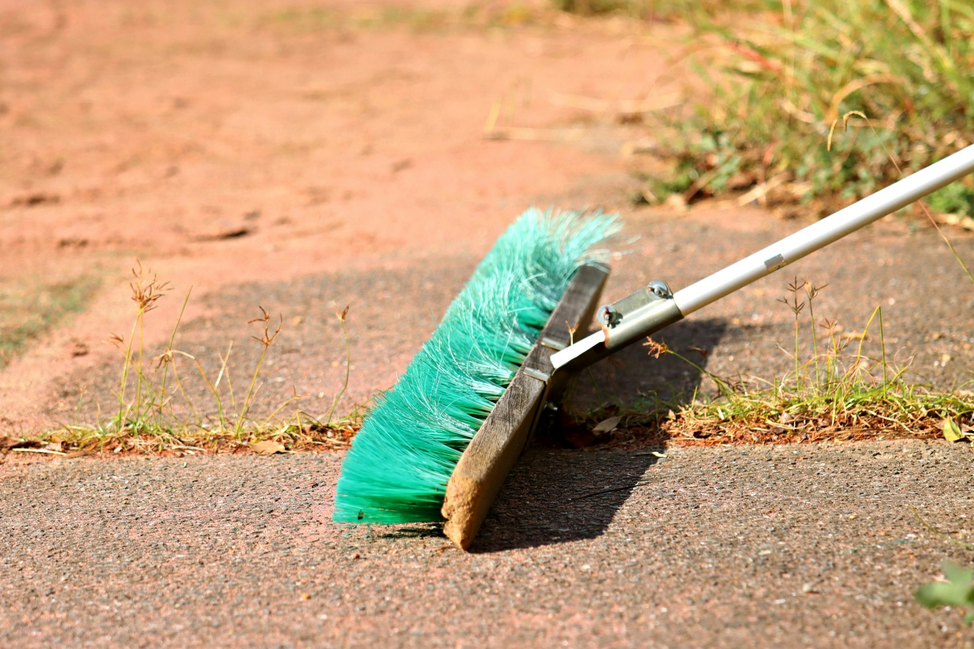 broom and dustpan cleaning a road