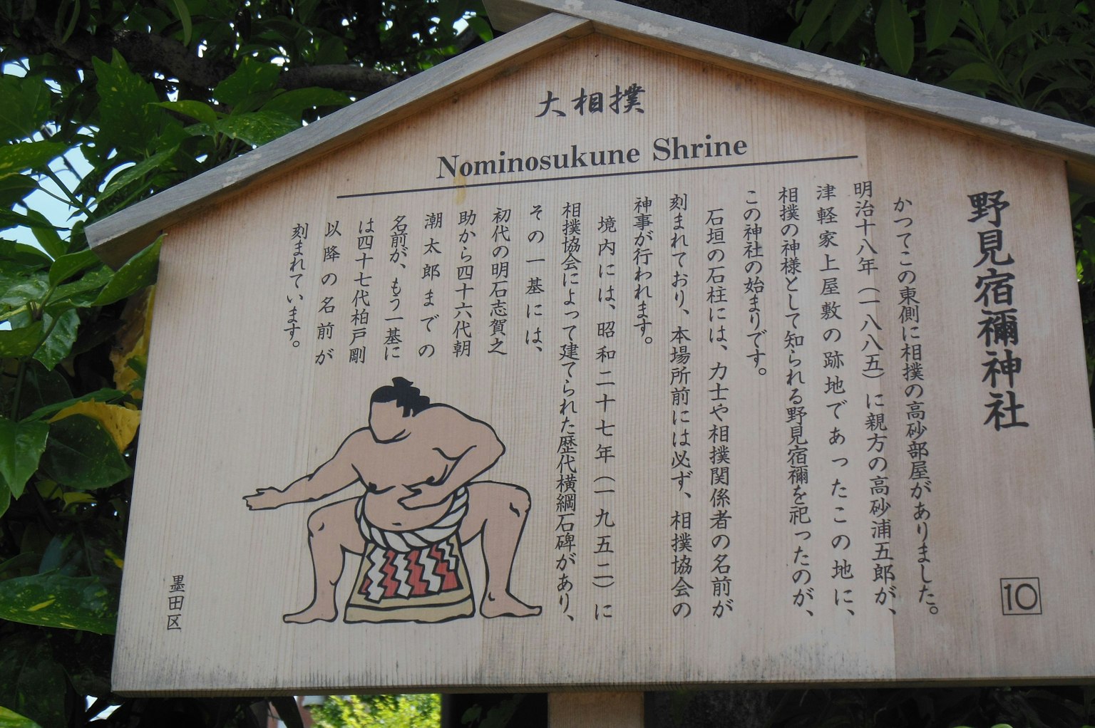 Papan informasi untuk Kuil Naminusukune yang menampilkan ilustrasi pegulat sumo dan teks deskriptif