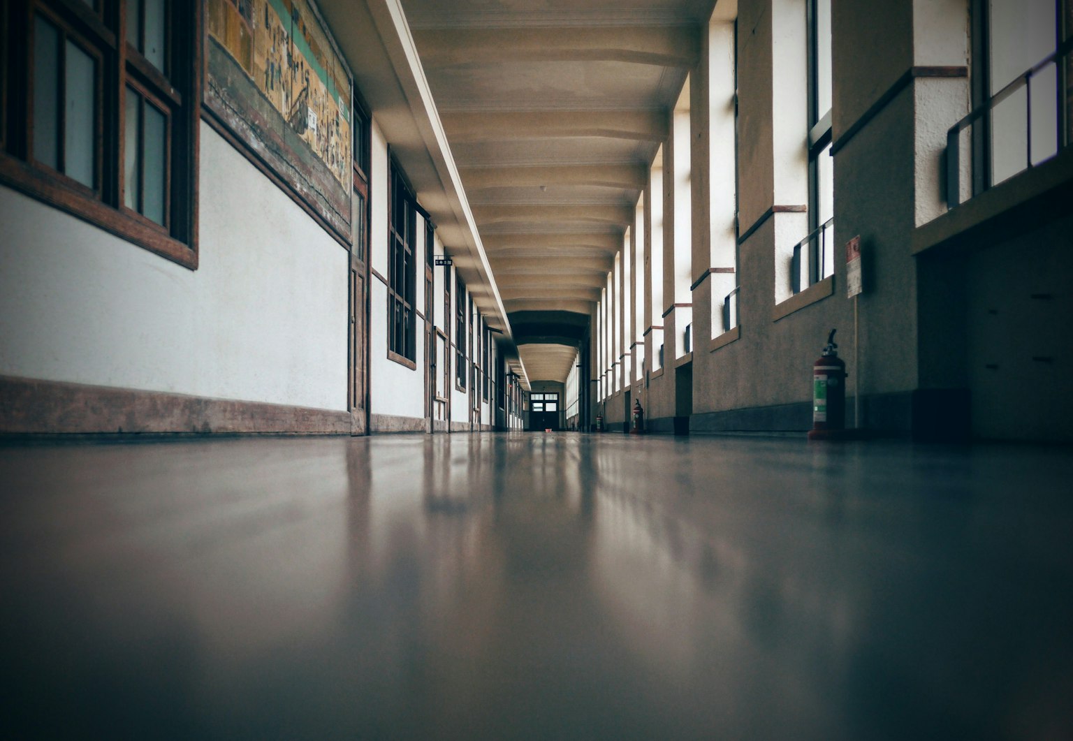 Foto di un lungo corridoio con finestre lungo le pareti e opere d'arte sulle pareti