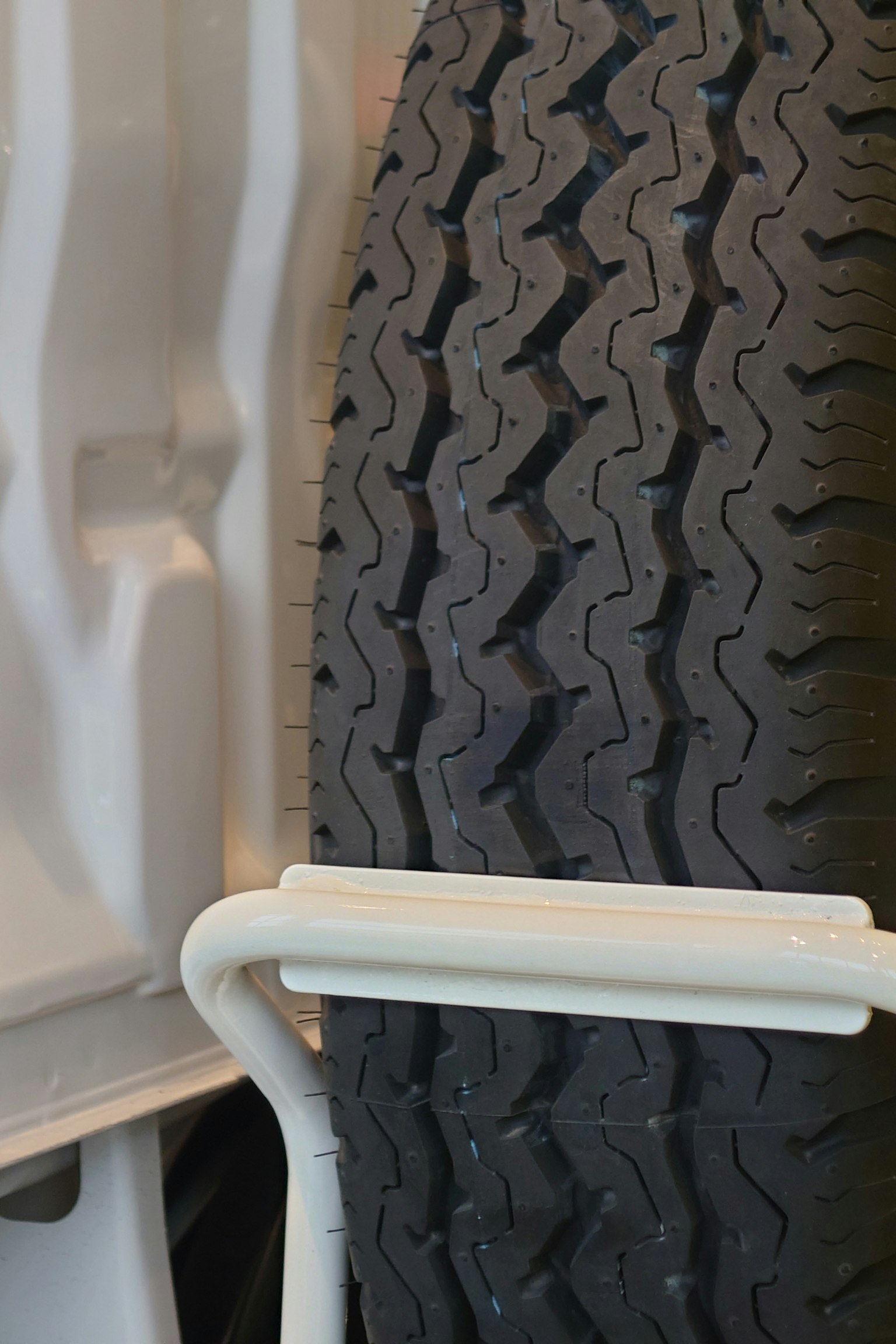Close-up of a tire tread pattern with a white metal frame visible