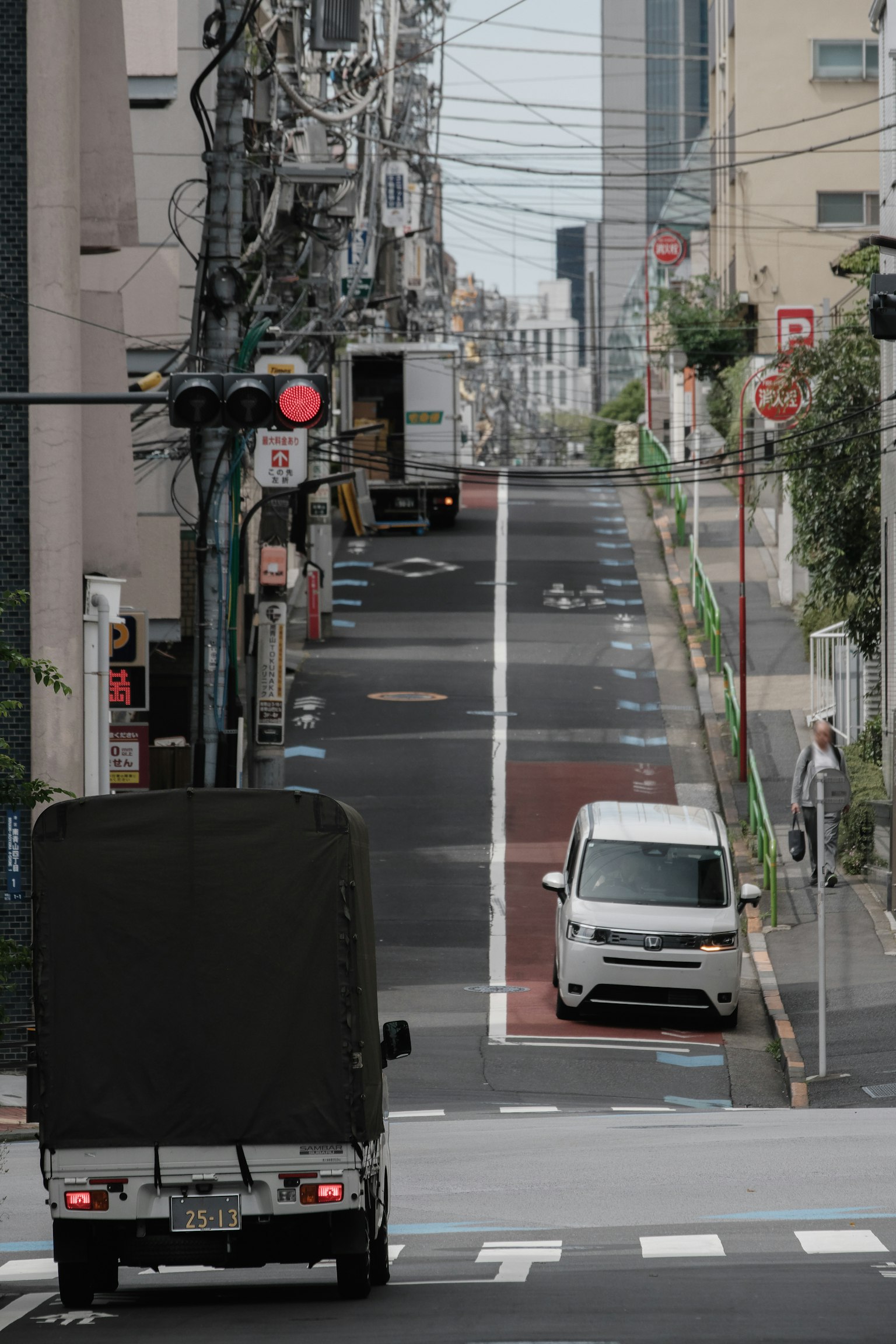 Ein Lkw, der eine abschüssige Straße hinunterfährt, mit einem weißen Auto in der Nähe
