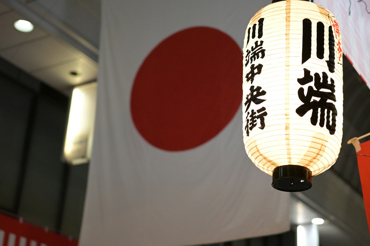 Scène nocturne avec le drapeau japonais et une lanterne avec le texte Kawabata Nakadori