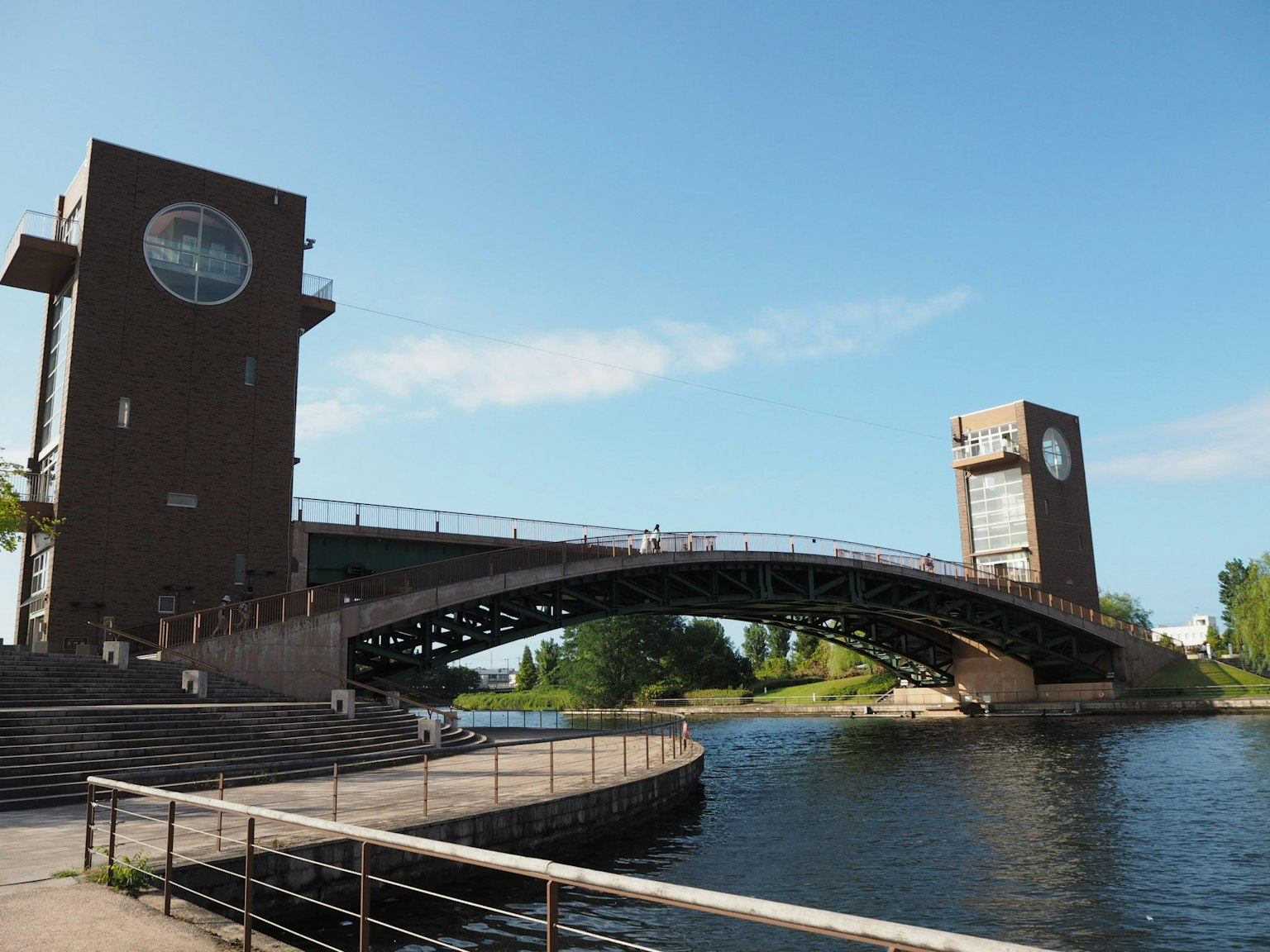 Puente de diseño moderno con dos torres y paisaje ribereño