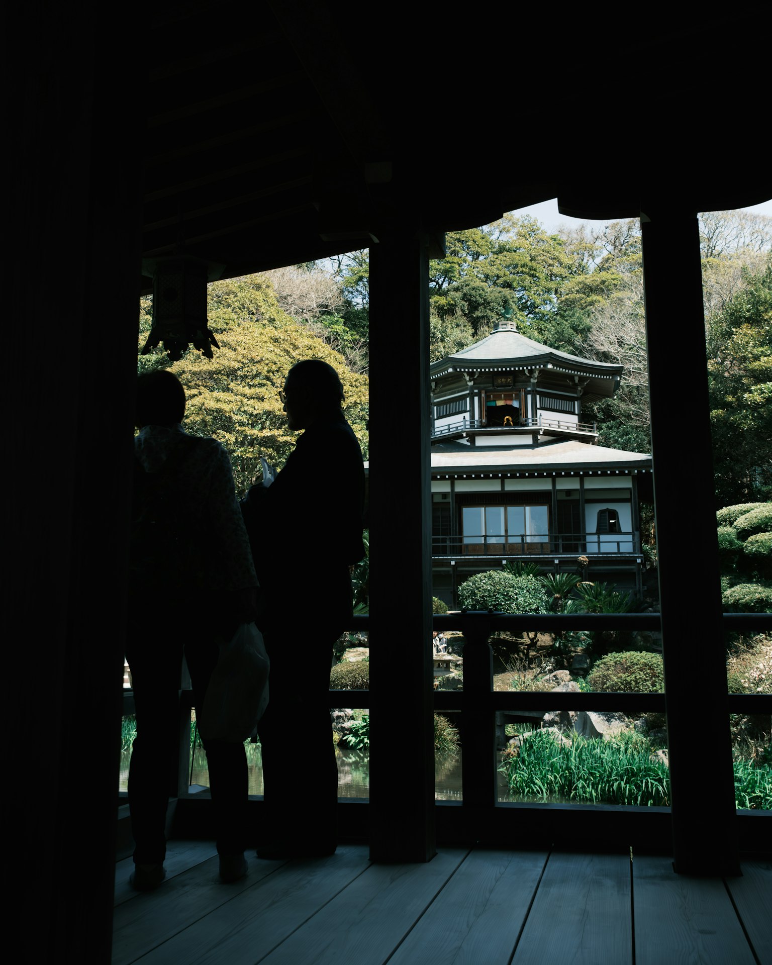 Silueta de personas en un jardín japonés tradicional con una pagoda de fondo