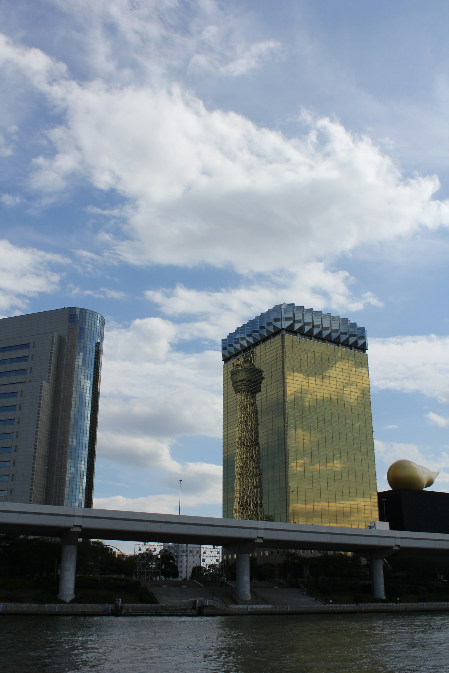 Golden skyscraper near the river under a blue sky