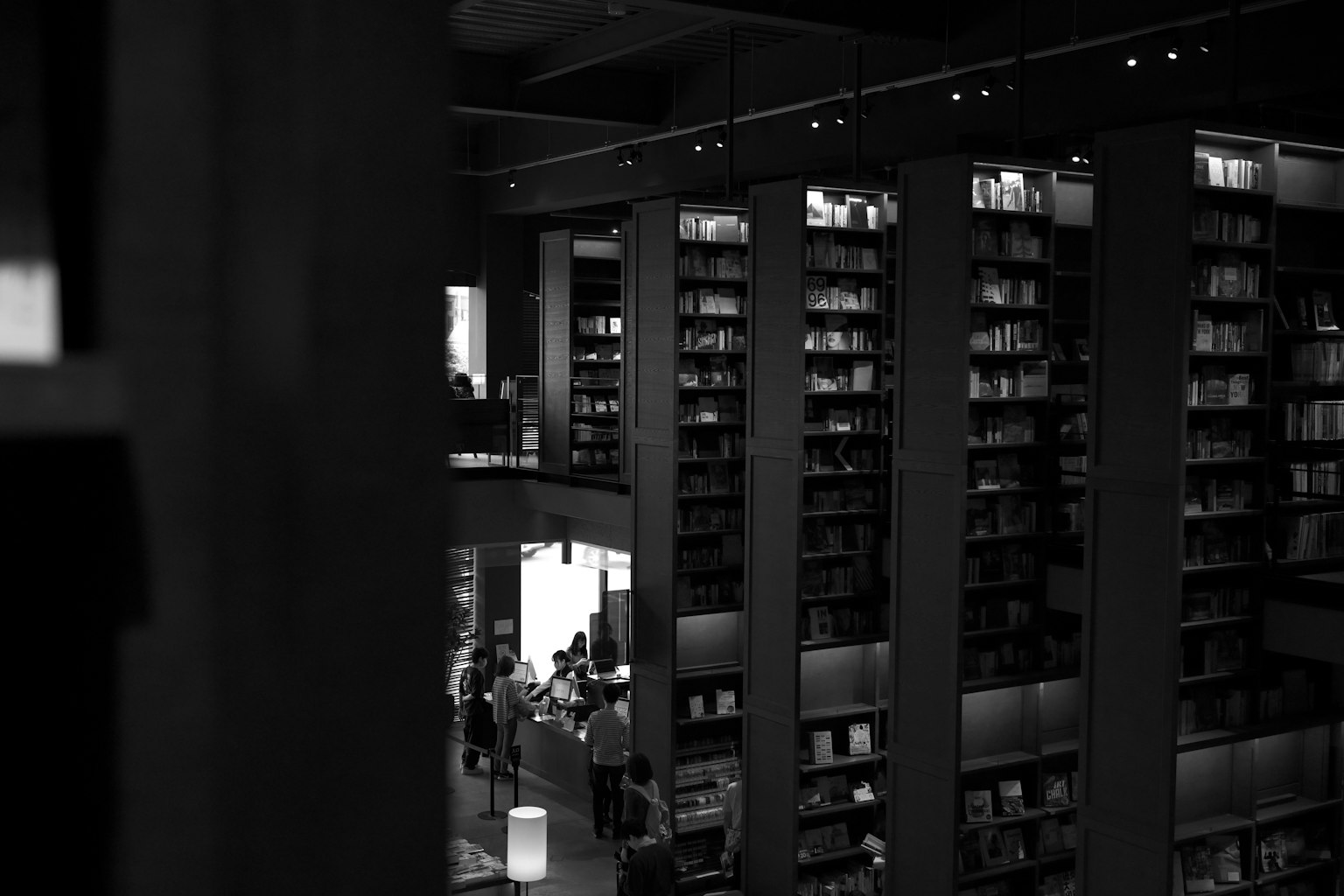 黒と白の書店の内部大きな書棚と人々の姿