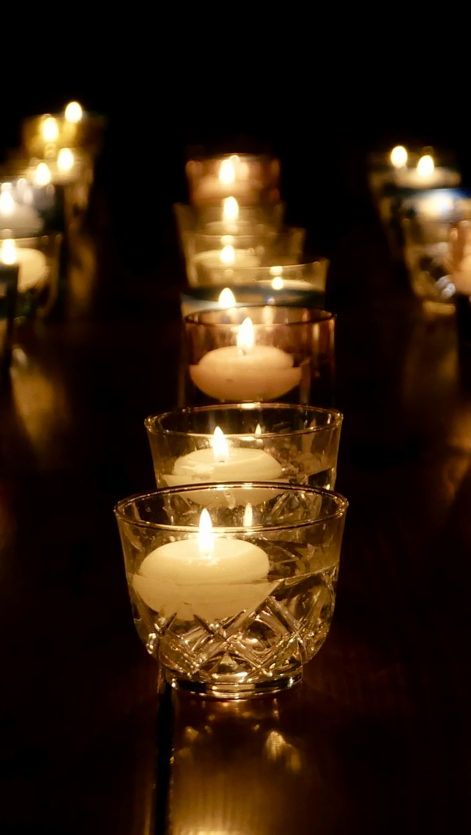 キャンドルが並ぶ暗い背景の中での温かい光