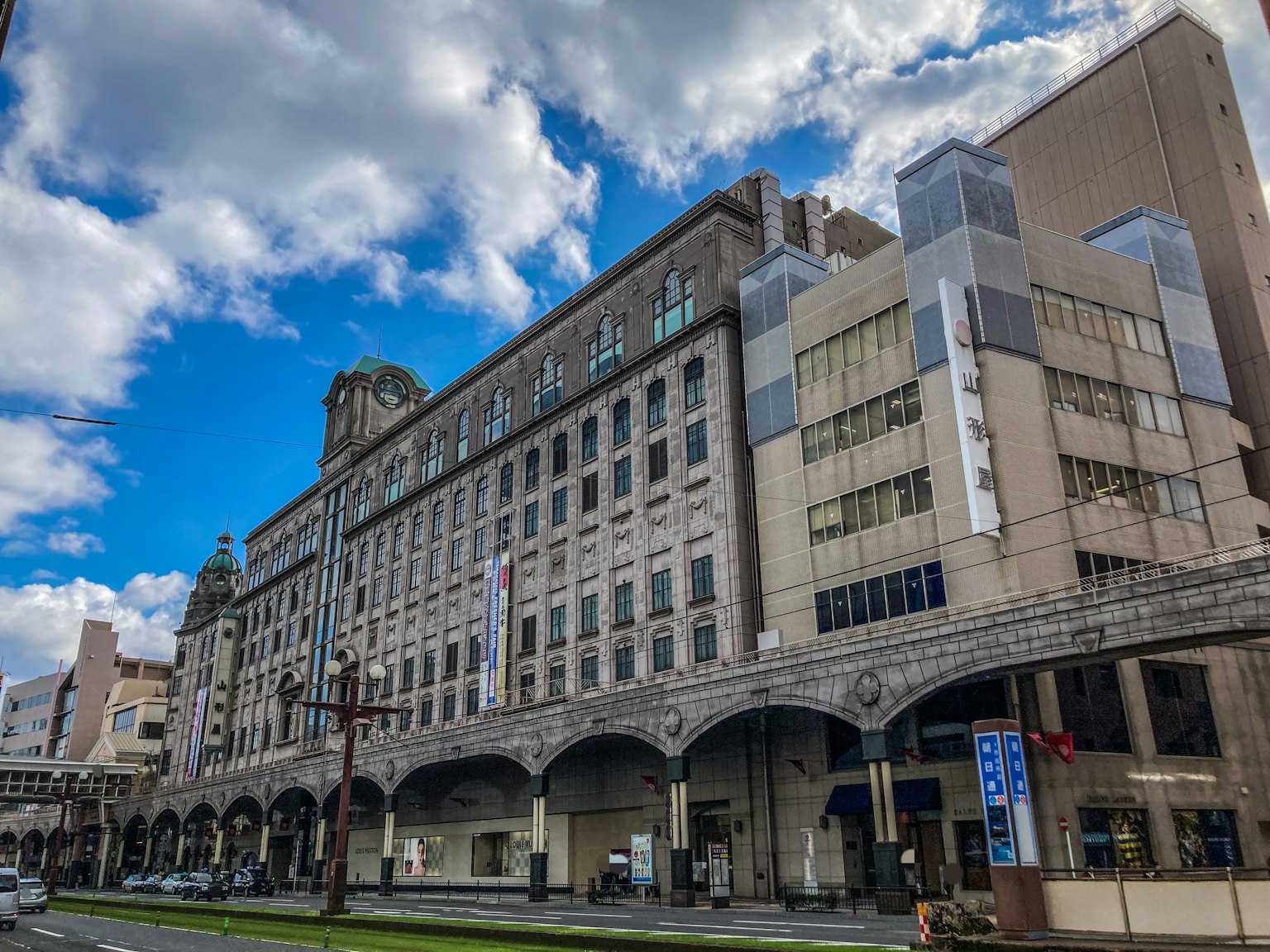 Fachada de un edificio histórico con arcada bajo un cielo azul