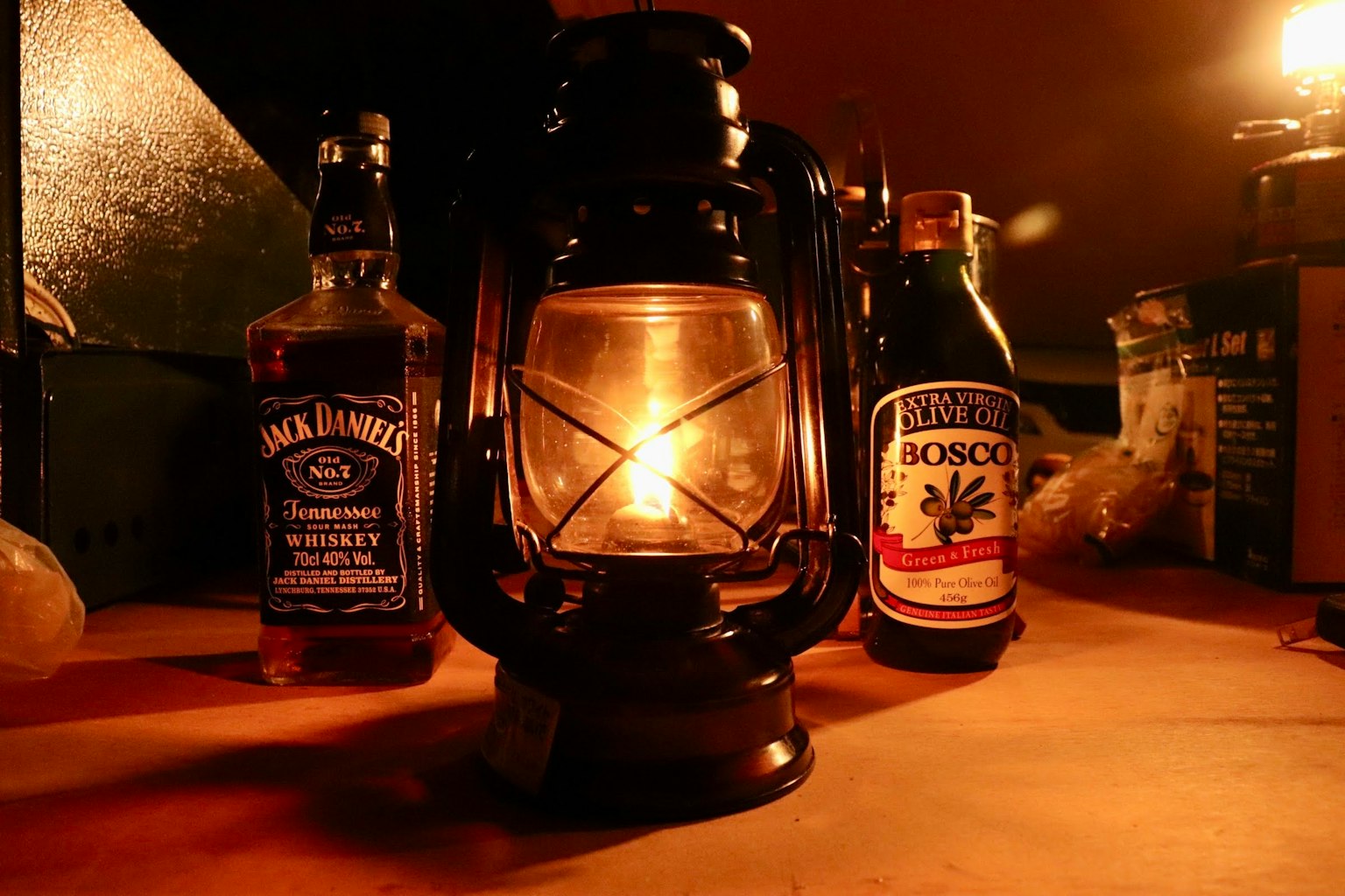 Una linterna vintage iluminada con botellas de whisky en un entorno tenue