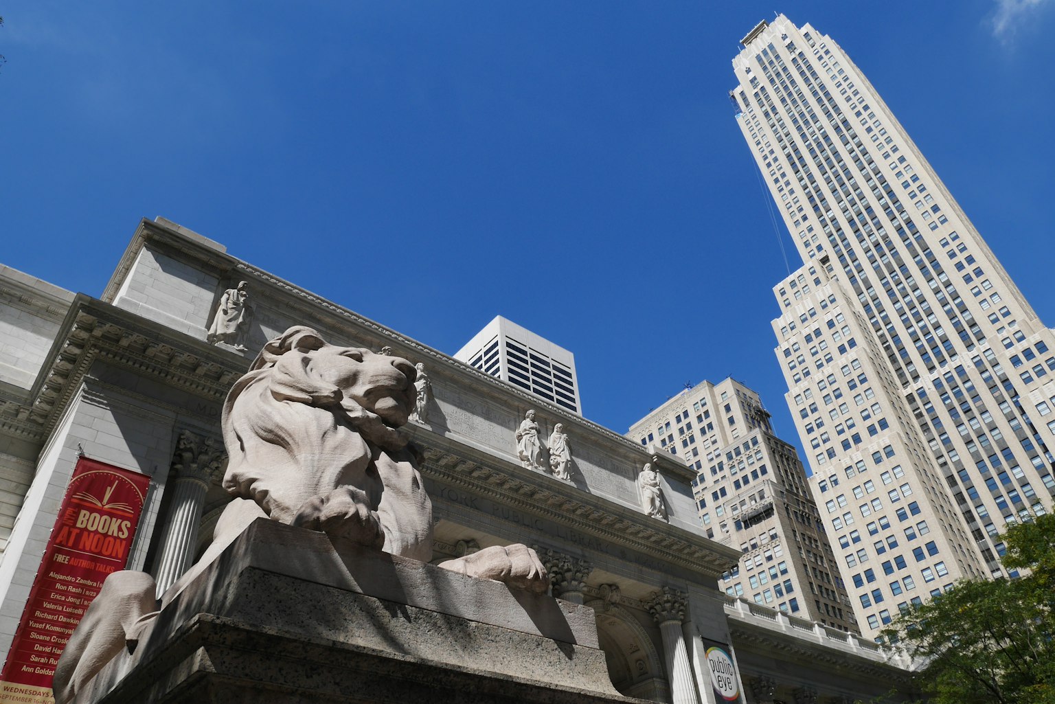 Sculpture de lion devant l'Empire State Building sous un ciel bleu