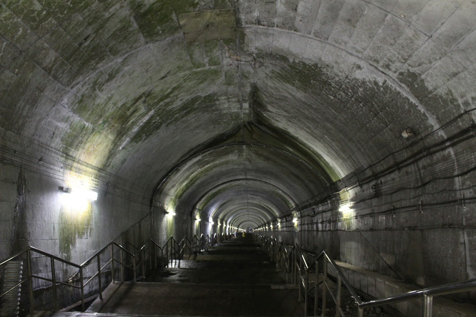 Innenansicht eines langen Tunnels, beleuchtet von Lichtern