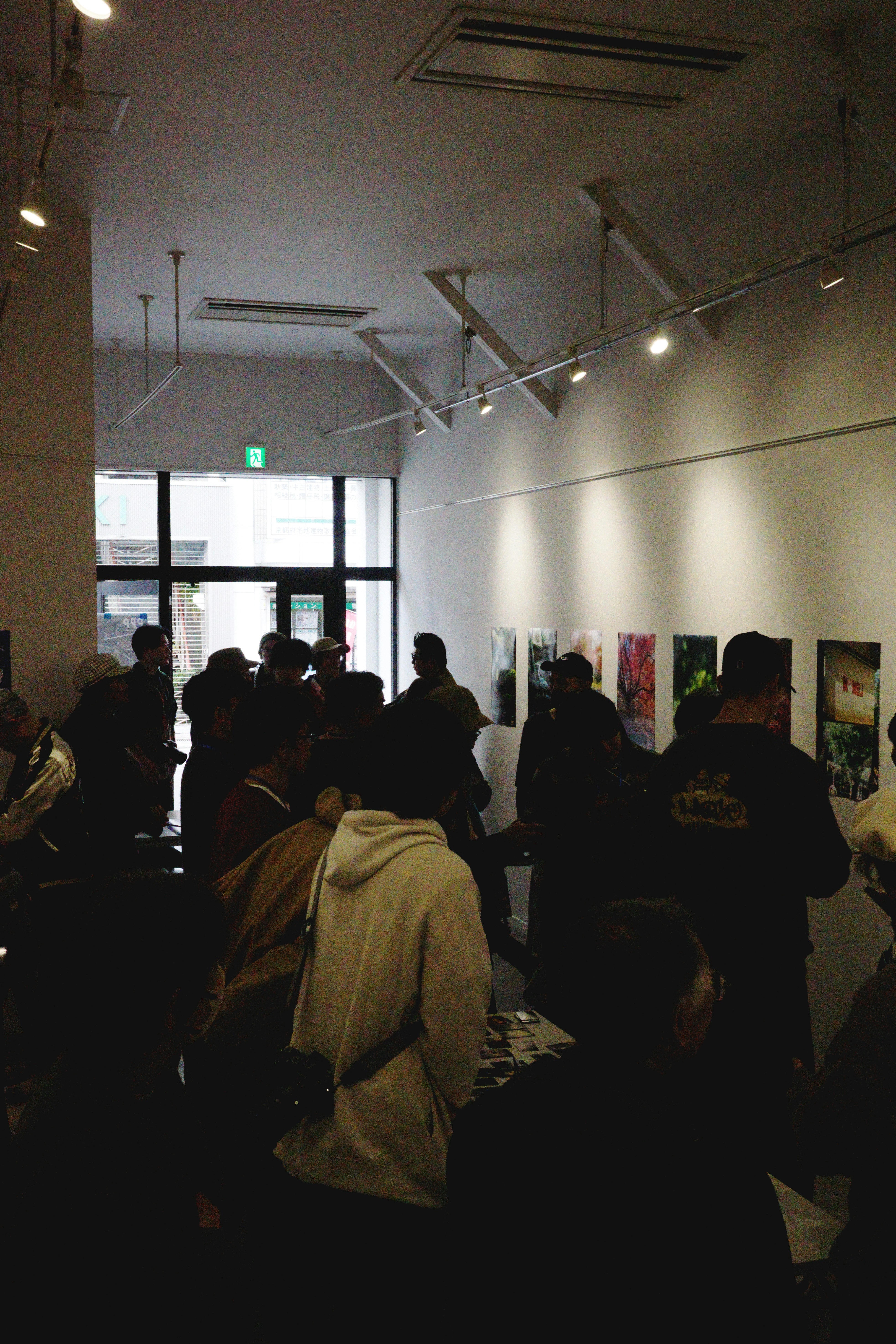 展示室で人々が並ぶギャラリーの室内風景
