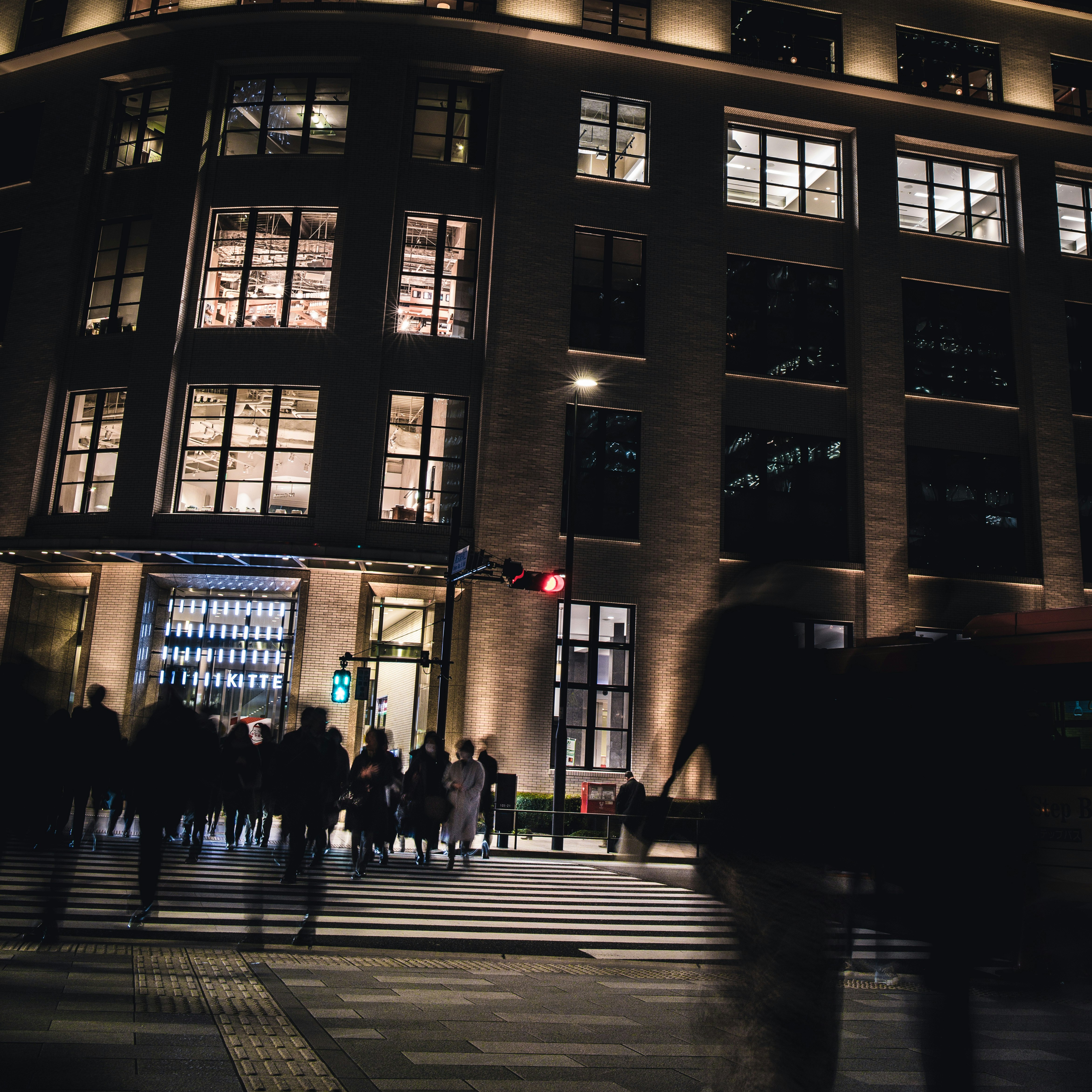 夜晚大型建筑前行人穿行的街景
