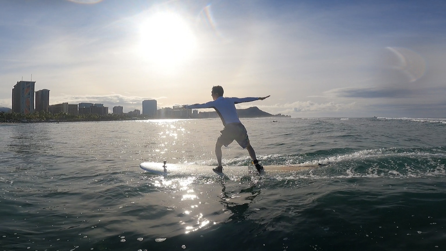 Uomo che fa surf con uno skyline urbano sullo sfondo