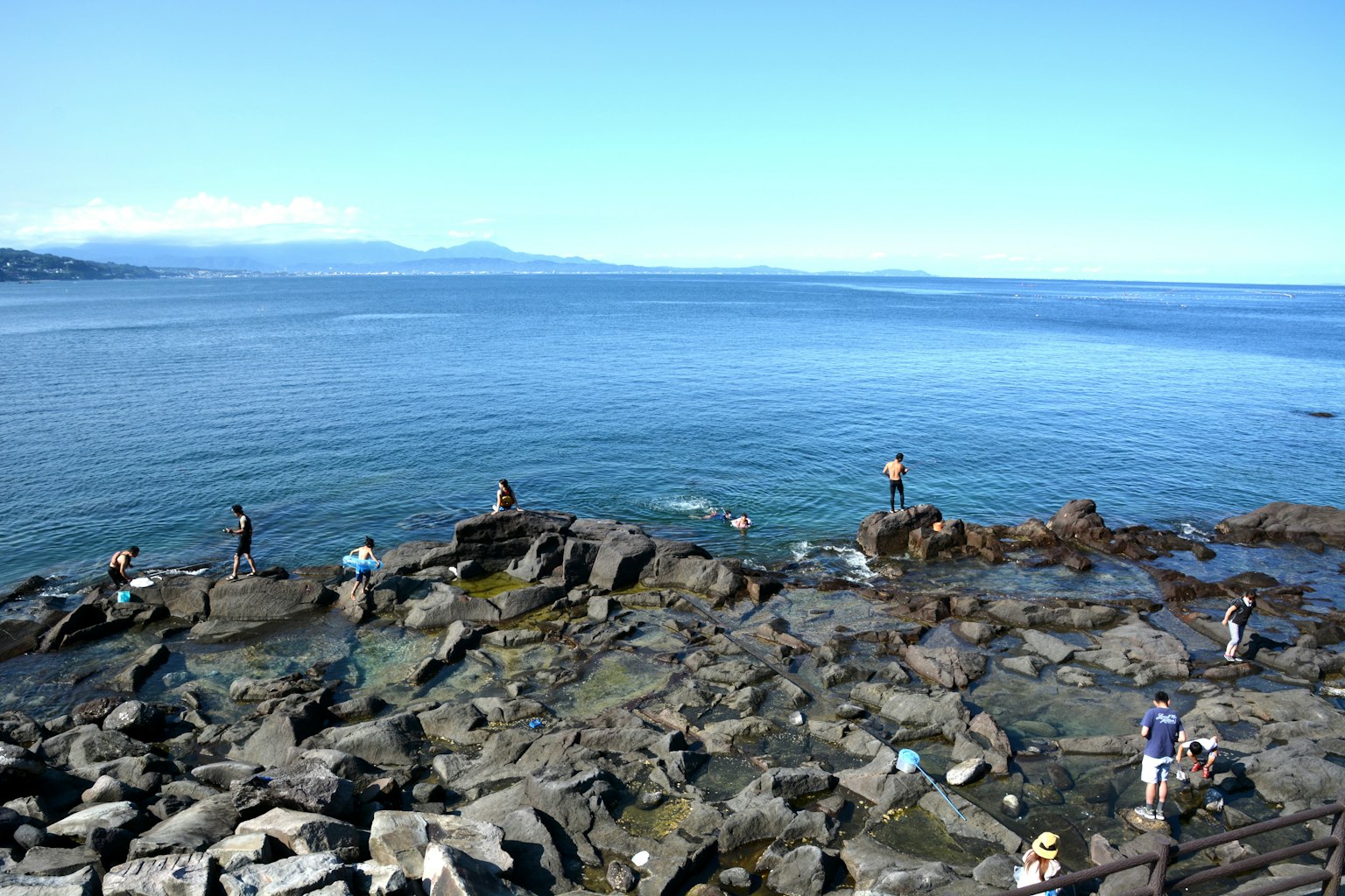 Des gens explorant des rivages rocheux au bord de la mer bleue